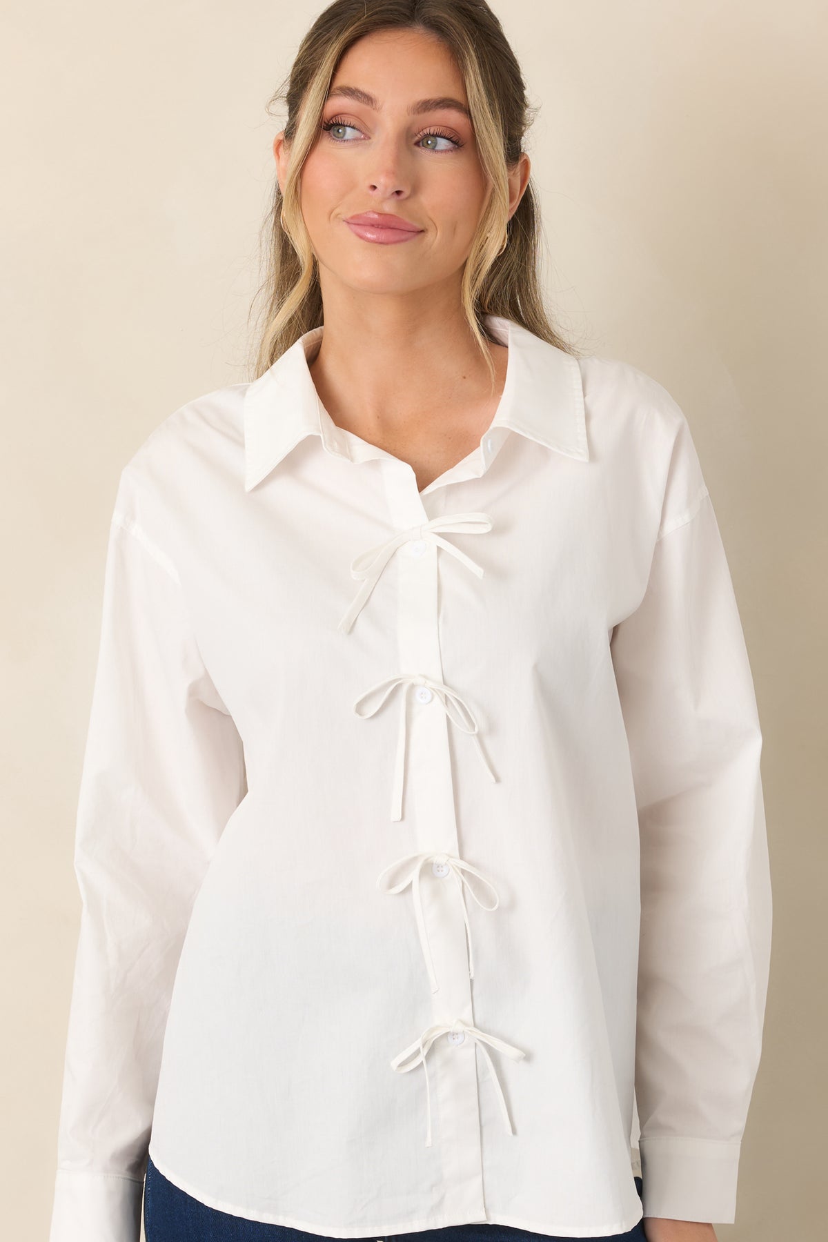 Detailed view of the functional button front with small white bow accents adding a feminine touch to the cotton fabric.