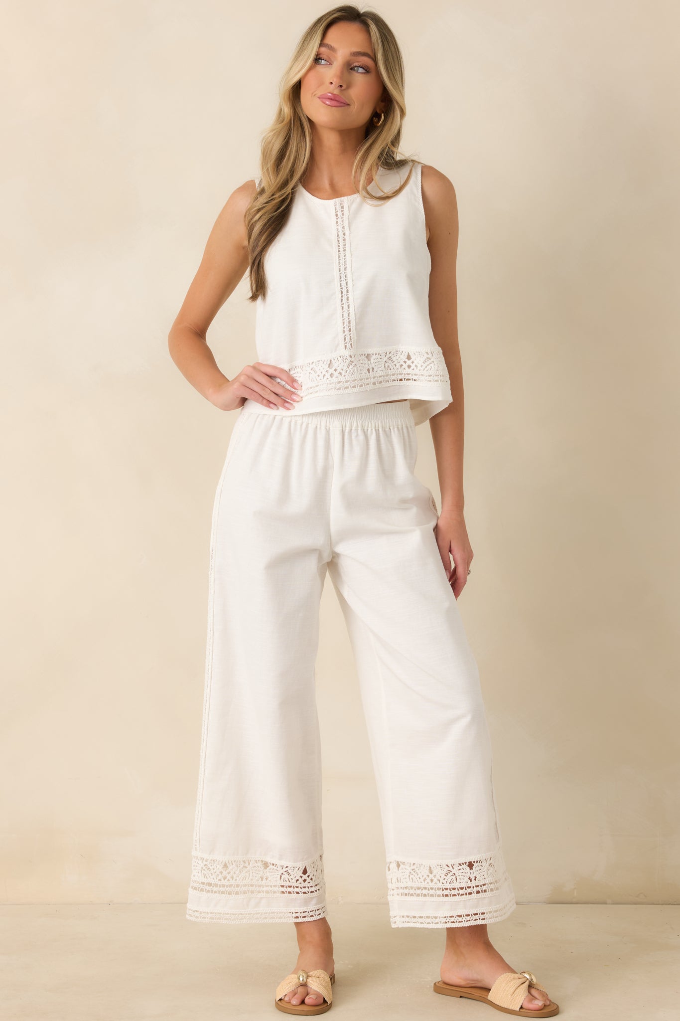 Relaxed-fit white top featuring breathable cotton-linen fabric, decorative embroidery, and a clean sleeveless silhouette.