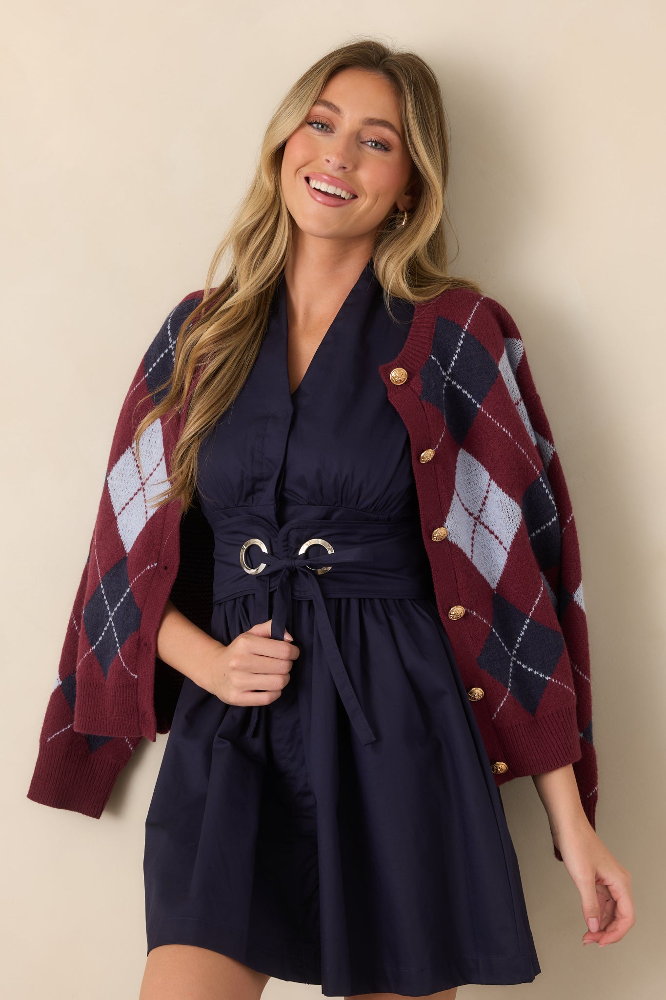 Detailed view of the dress showcasing the wide removable belt, metal grommets, tie closure, and defined waistline.