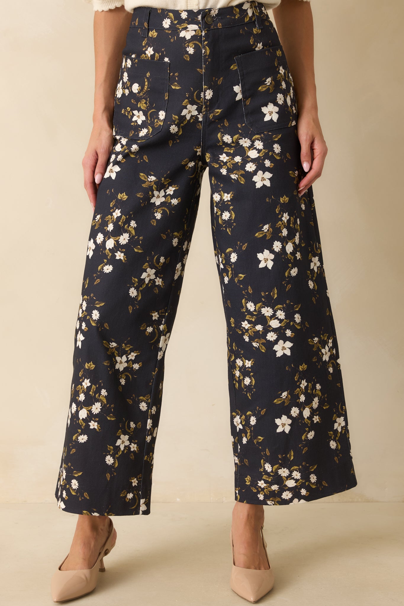 Wide leg opening of the floral denim jeans highlighted with the patterned fabric.