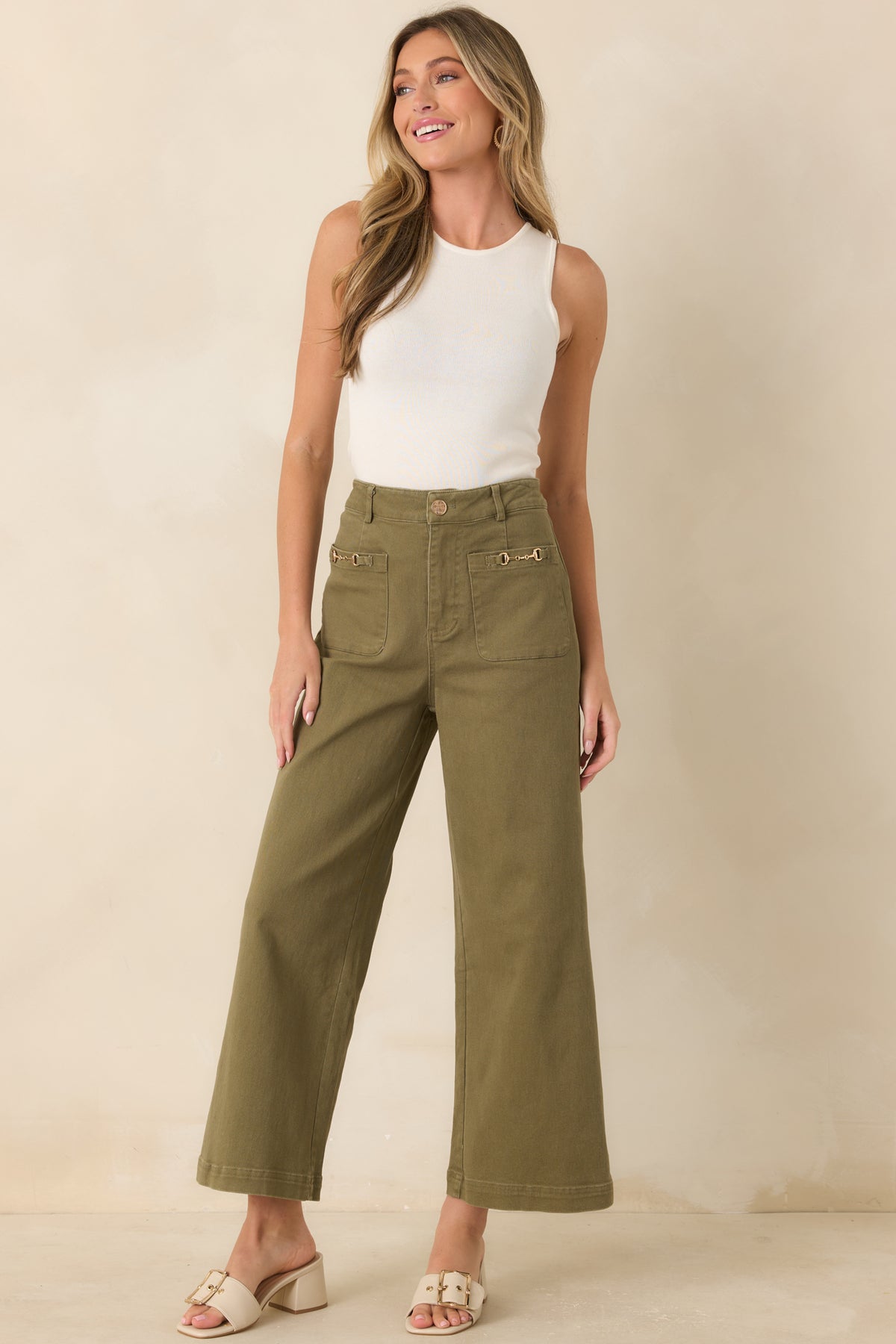 Wide leg high-rise jeans featuring a cropped ankle-length silhouette, oversized front pockets, and refined gold-tone accents.