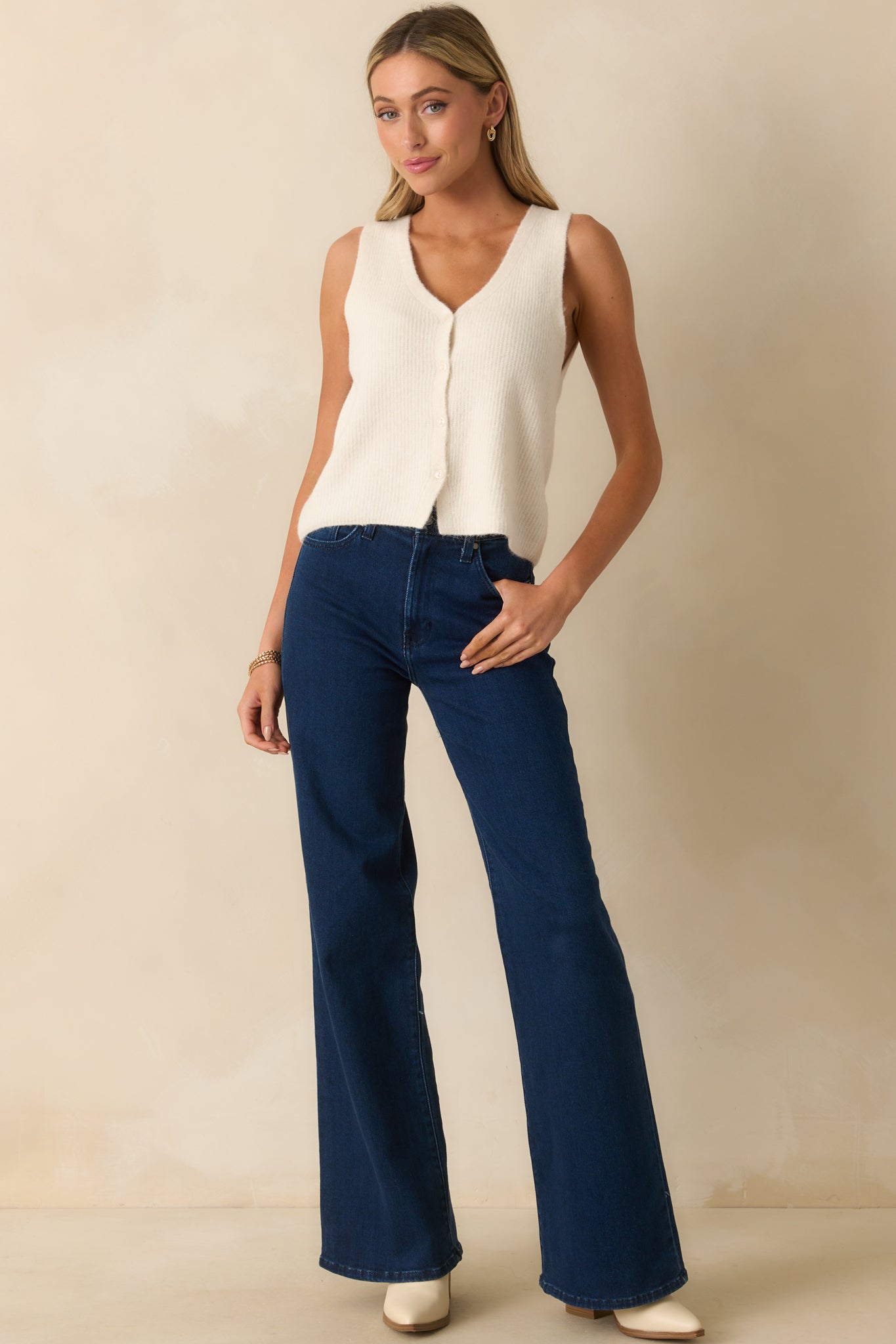 Wide-leg pants featuring a classic button and zipper closure and casual dark wash fabric.