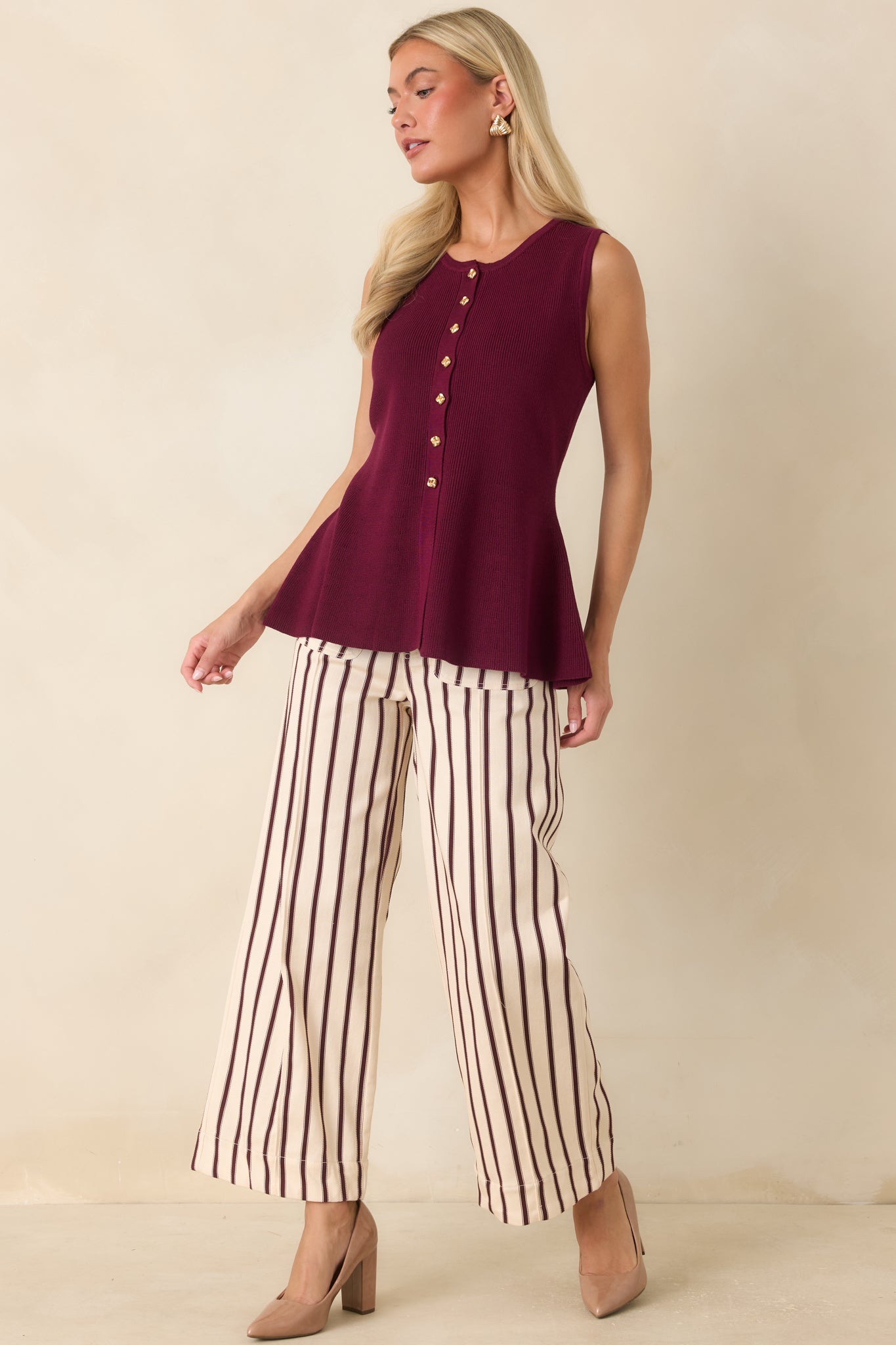 Wide-leg striped pants showcasing a polished silhouette, oversized front pockets, and decorative button accents for a modern finish.