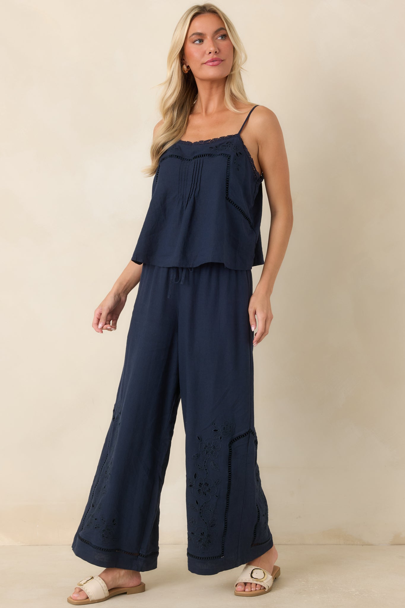 Wide leg pants featuring a linen rayon blend fabric, relaxed silhouette, and floral embroidery along the lower legs.