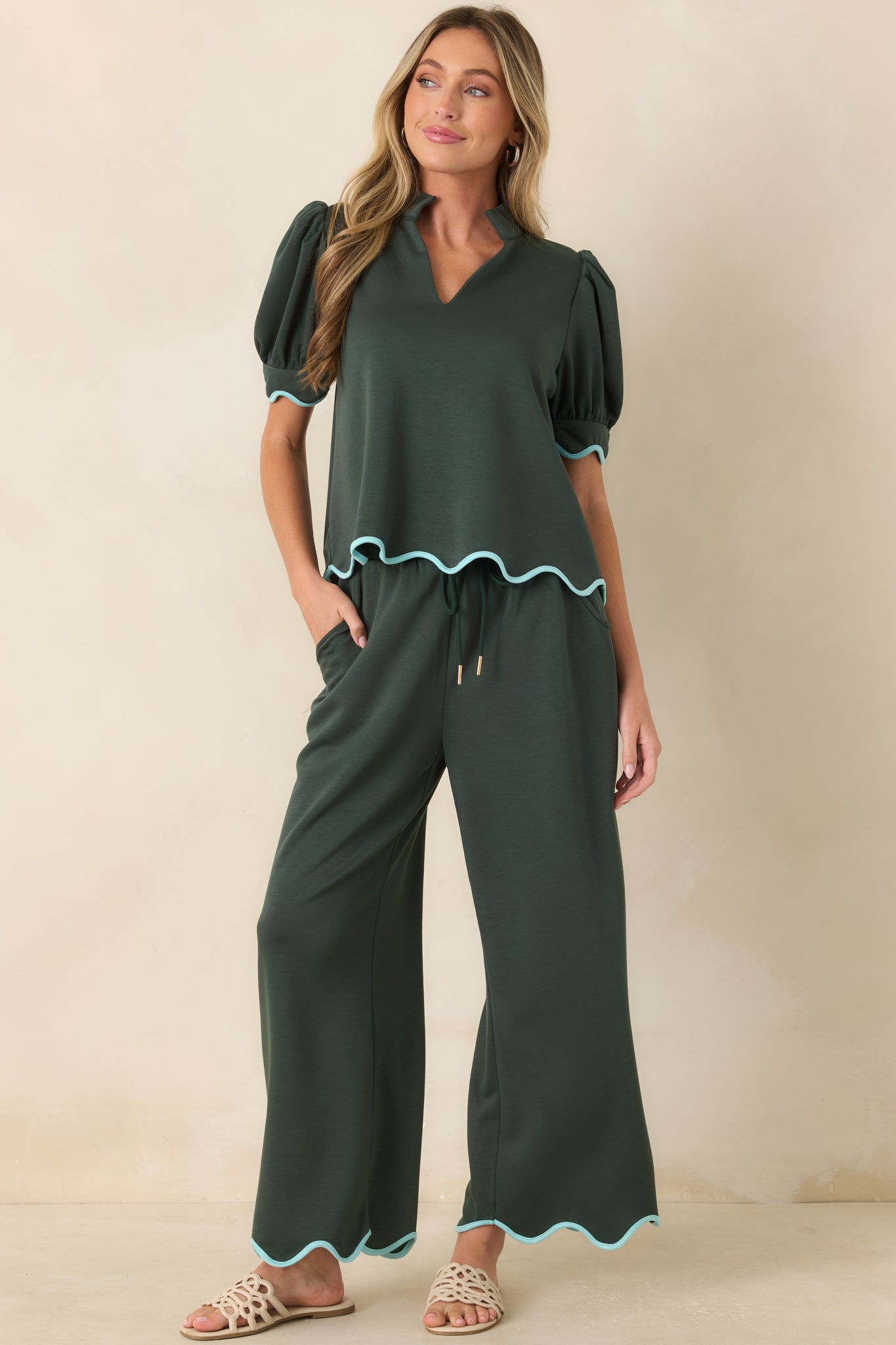 Wide leg pull-on pants with gold-tone cord ends, side pockets, and soft flowing knit fabric.