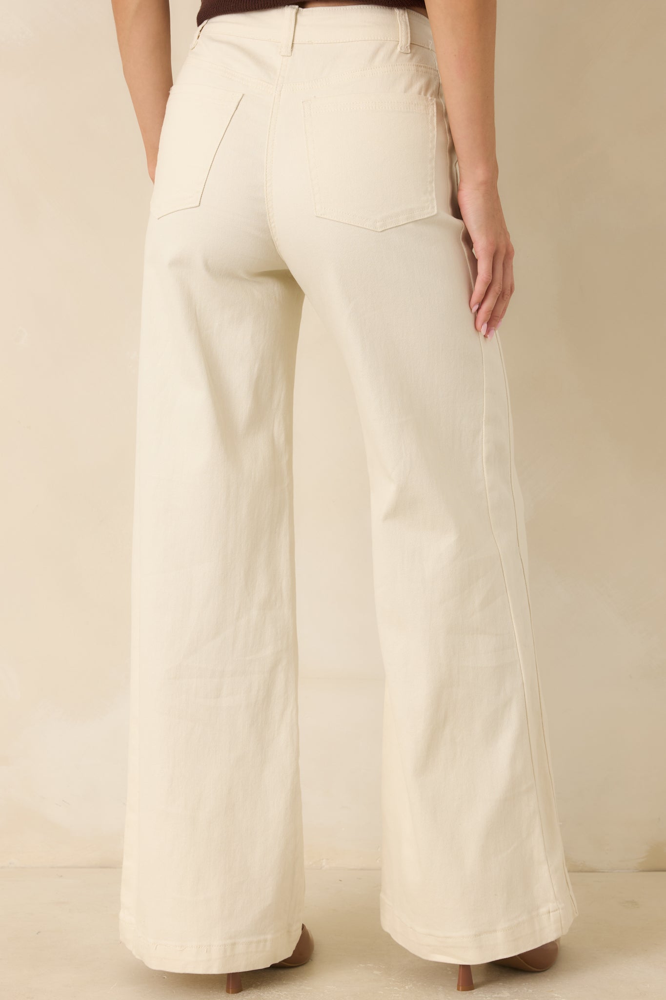 Rear view of the high-rise wide leg jeans featuring functional back pockets and a relaxed full-length silhouette.