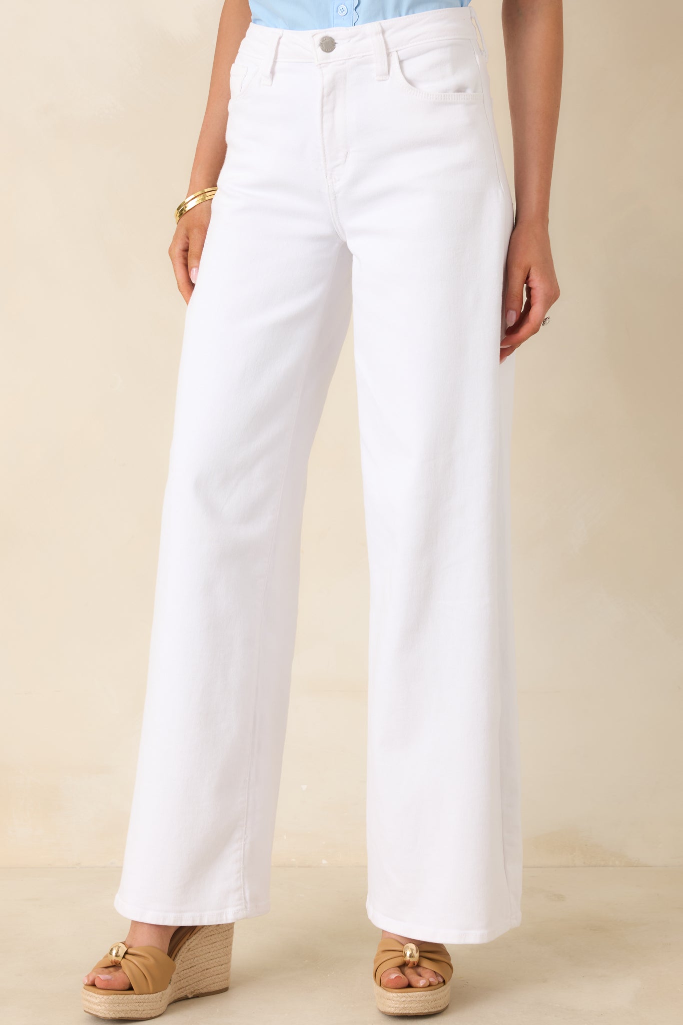 Close crop of white wide-leg jeans emphasizing the crisp fabric and straight, flowing leg shape.