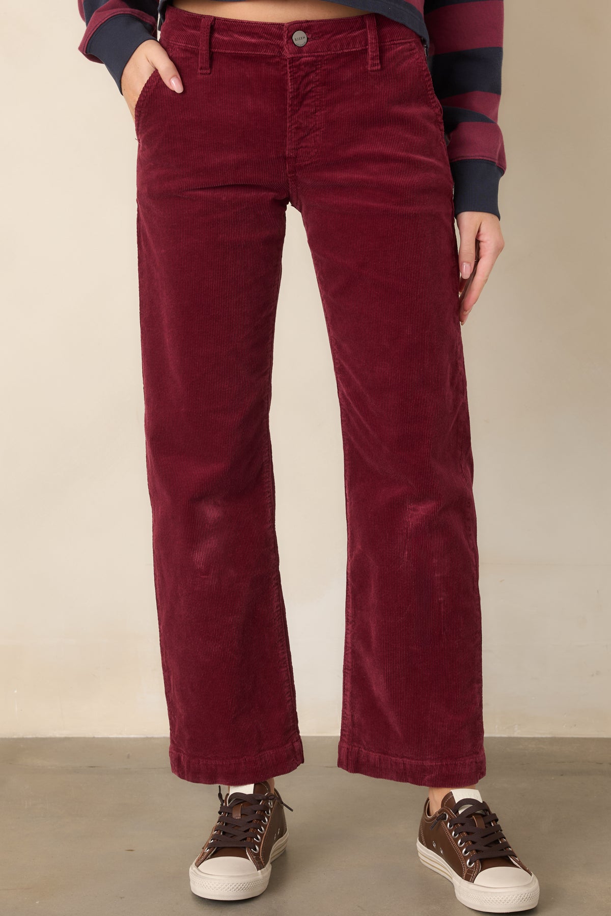 Wine corduroy pants showcasing the textured fabric, cropped straight-leg silhouette, waistband, and slanted front pocket design.