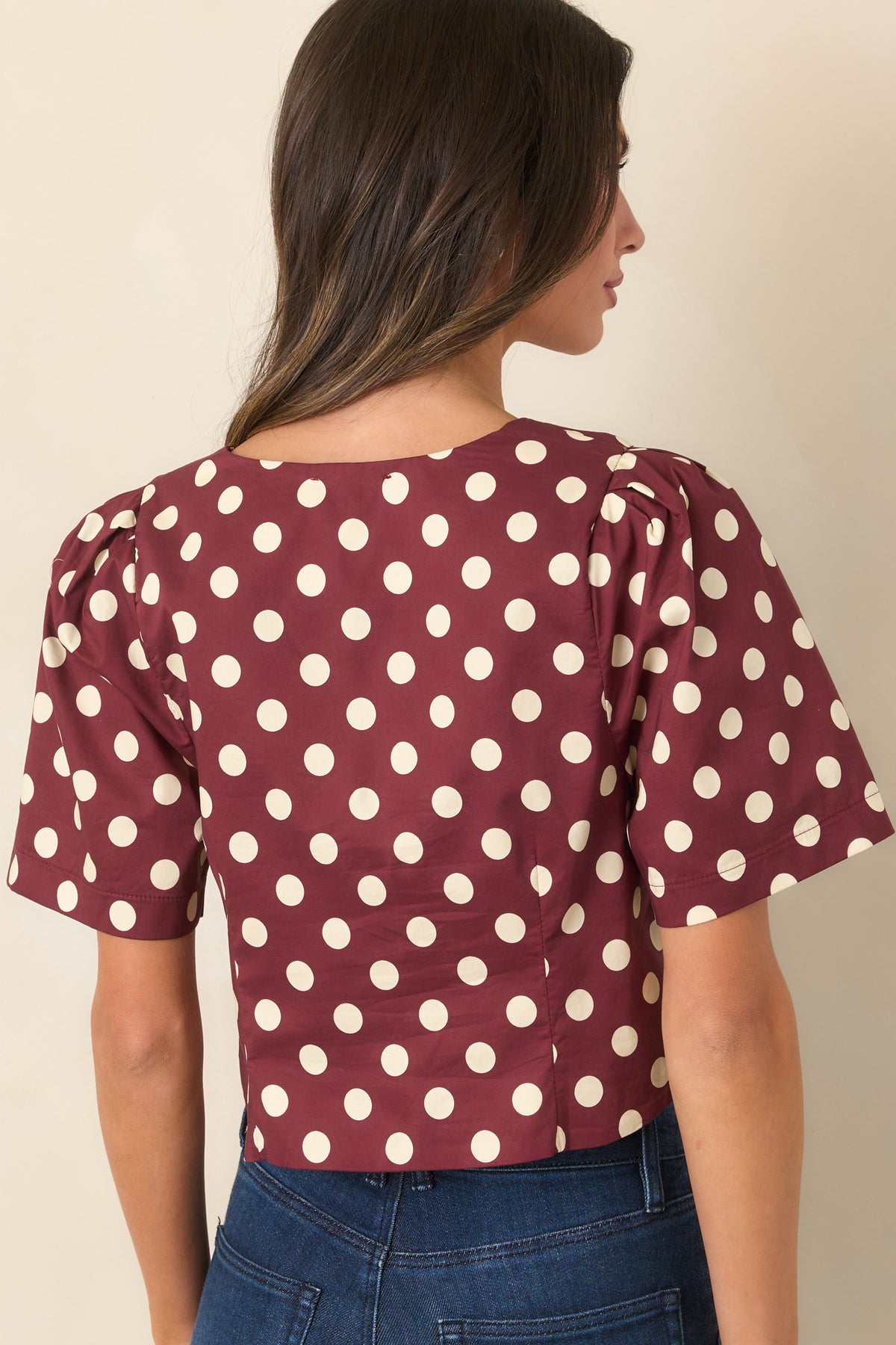 Rear of the wine and ivory polka dot cropped top showing the gathered shoulders and tailored bodice.