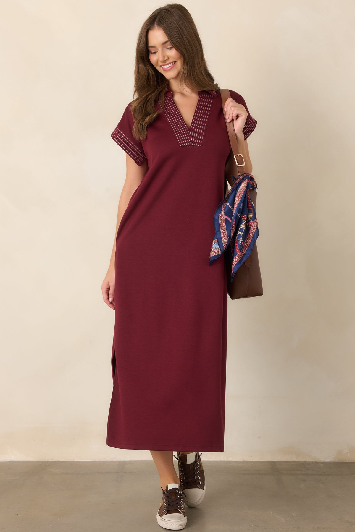 Wine knit maxi dress highlighting the contrast trim and structured collared V-neckline.