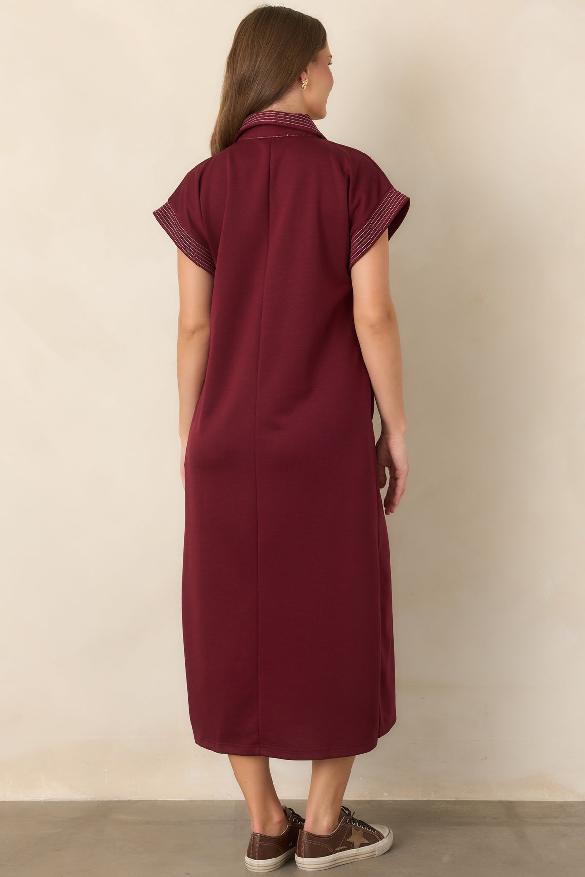 Rear of the wine knit maxi dress featuring contrast pinstriped trim, relaxed fit, and side slits.