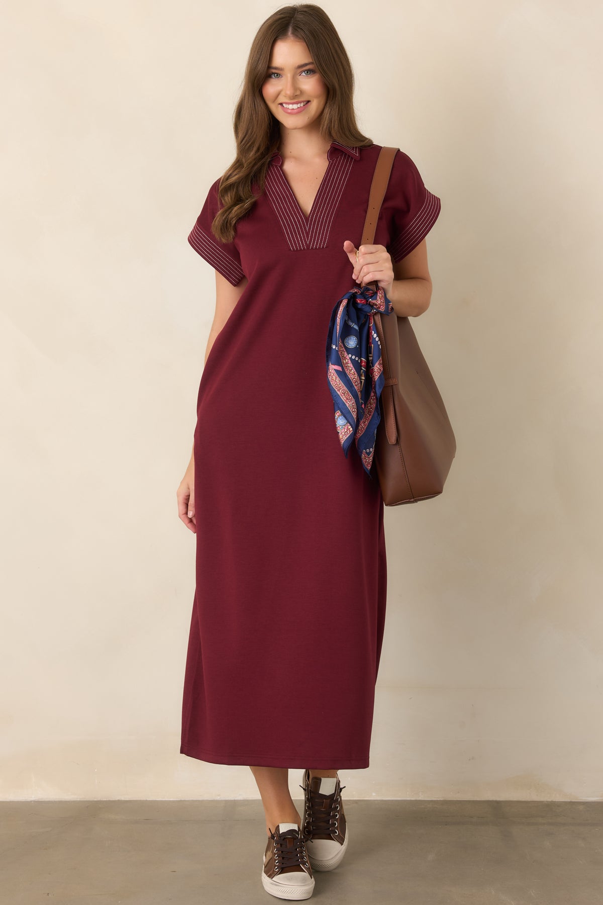 Wine knit maxi dress featuring contrast pinstriped trim, a collared V-neckline, and relaxed silhouette.