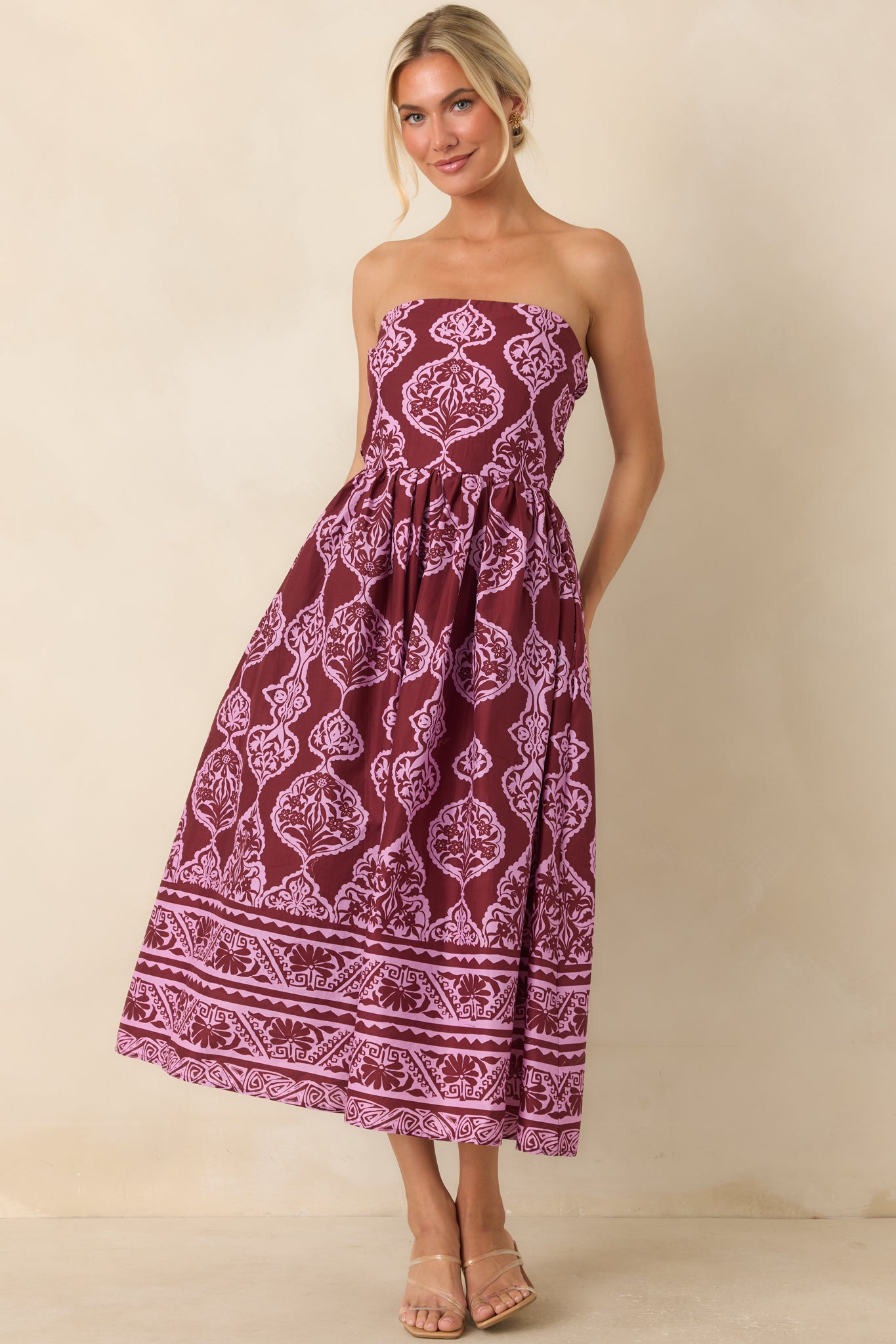Wine and orchid pink strapless midi dress featuring a medallion print, coordinating border hem, fitted bodice, and gathered skirt.