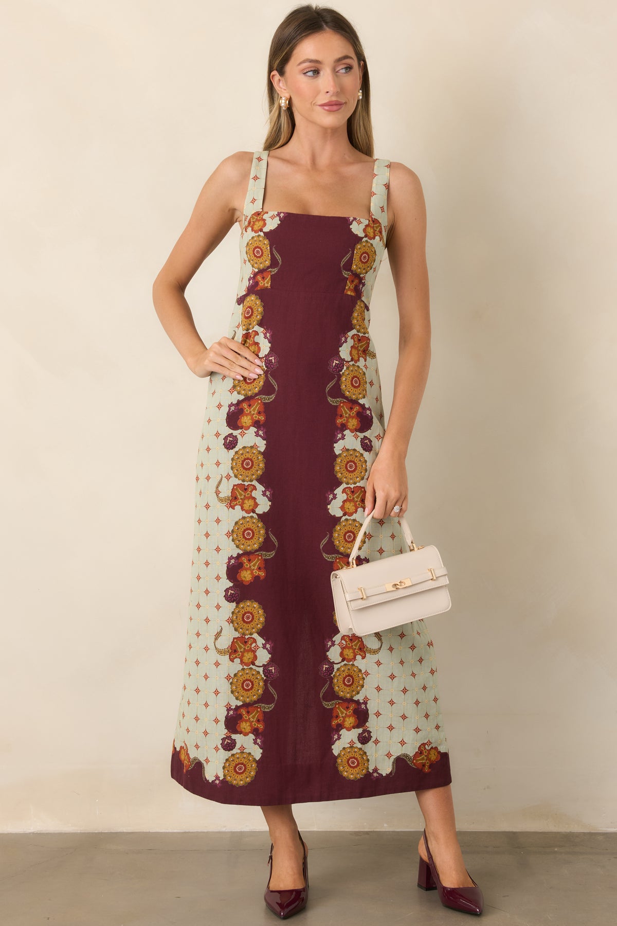 Wine midi dress featuring pale sage panels, ornate floral motifs, a square neckline, and defined waist.