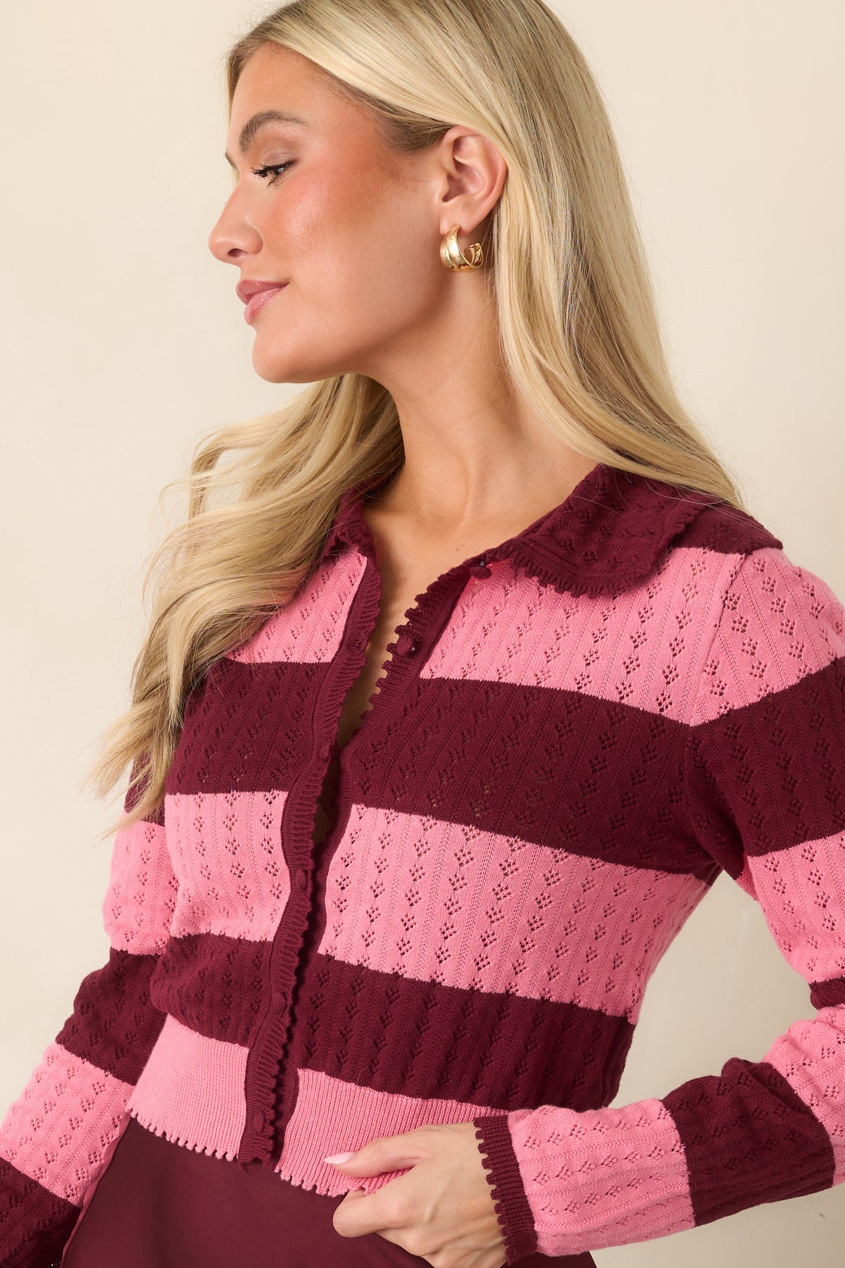 Wine and pink cropped cardigan highlighting the delicate pointelle openings between alternating color bands.