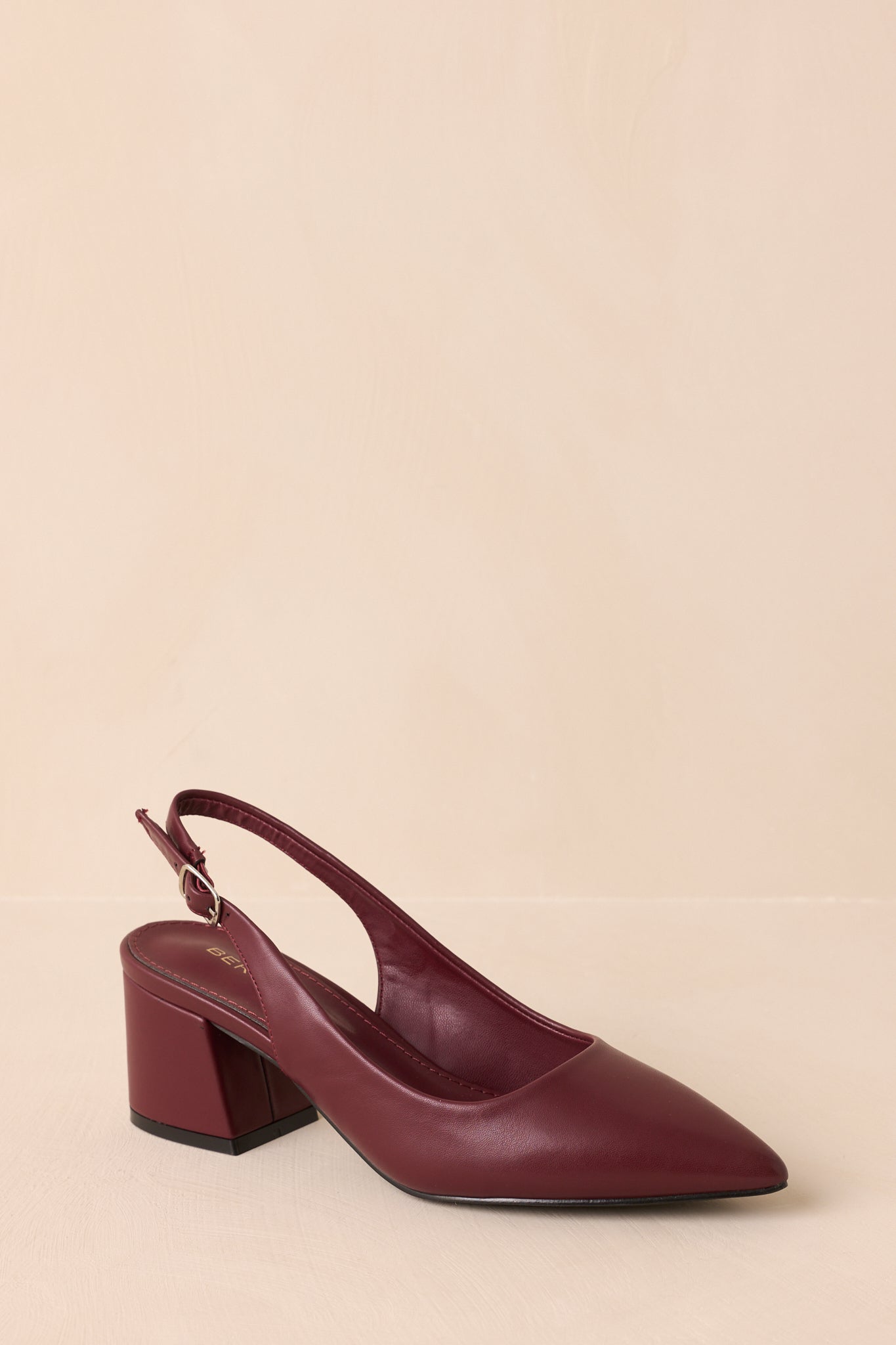 Three-quarter angle of wine red heels showing sleek silhouette and block heel.