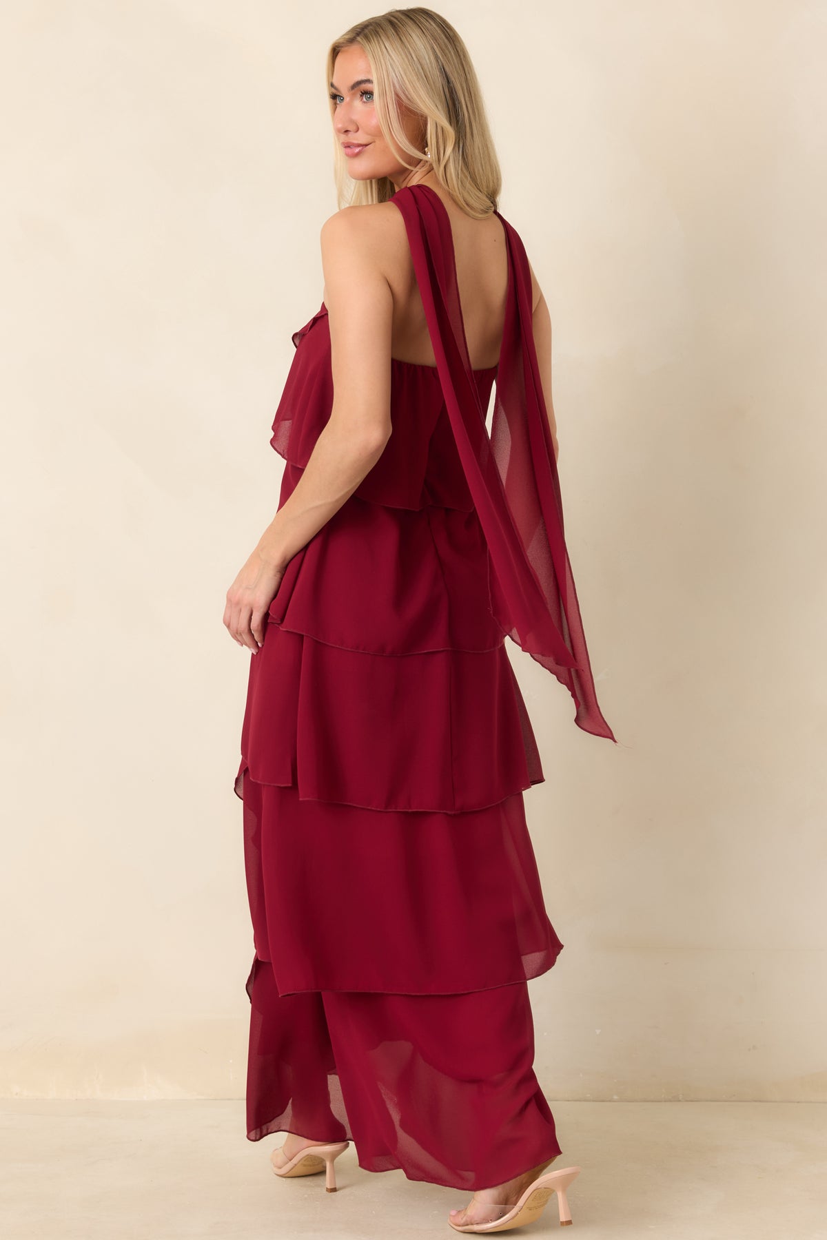 Rear view of the wine red strapless dress with the coordinating scarf trailing down the back above the flowing ruffled skirt.