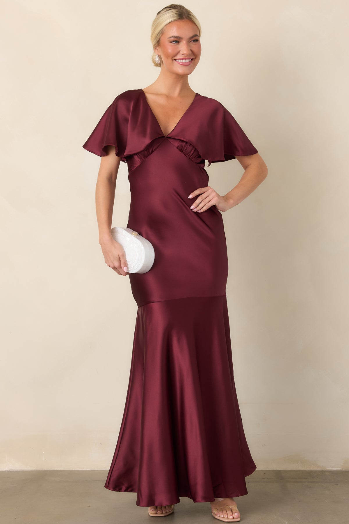 Lustrous satin maxi dress with sweeping flutter sleeves, defined waist, and flared hem construction.