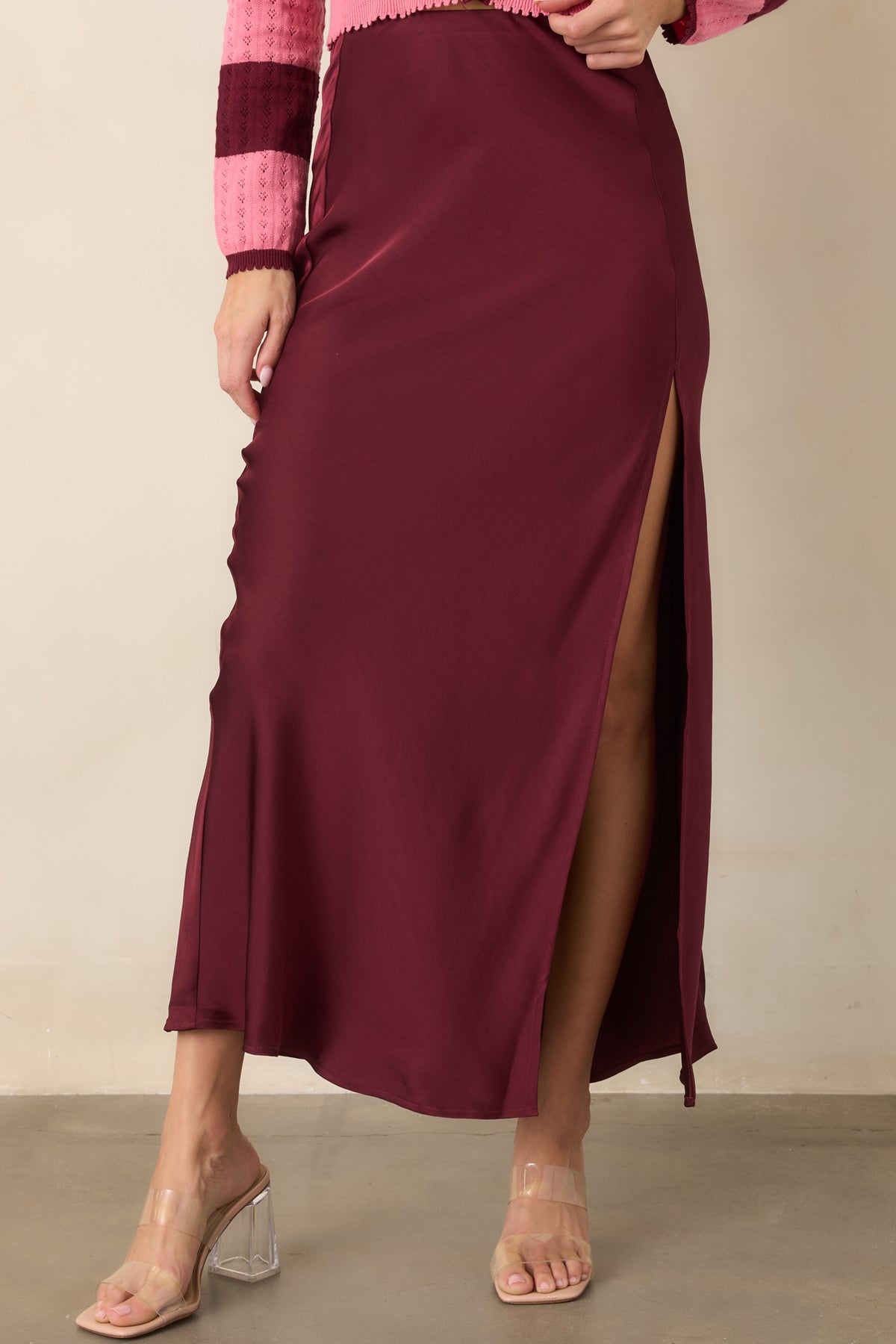 Wine satin midi skirt highlighting the side slit and subtle sheen of the fluid fabric.