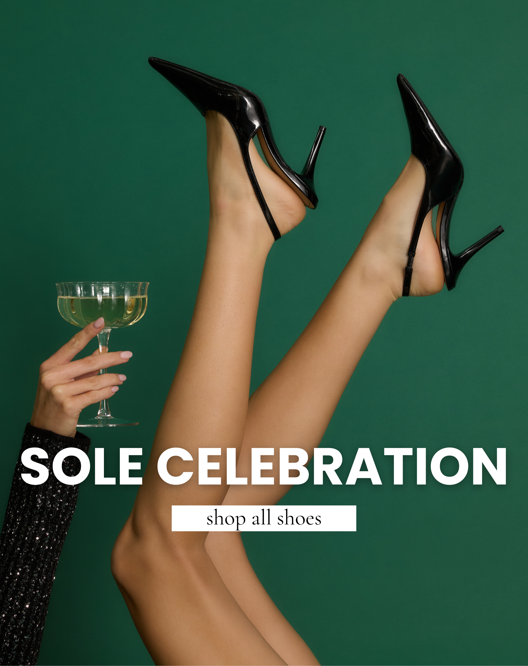 Model poses with legs raised wearing black patent pointed-toe heels while holding a champagne glass. Shop chic women’s holiday party shoes.