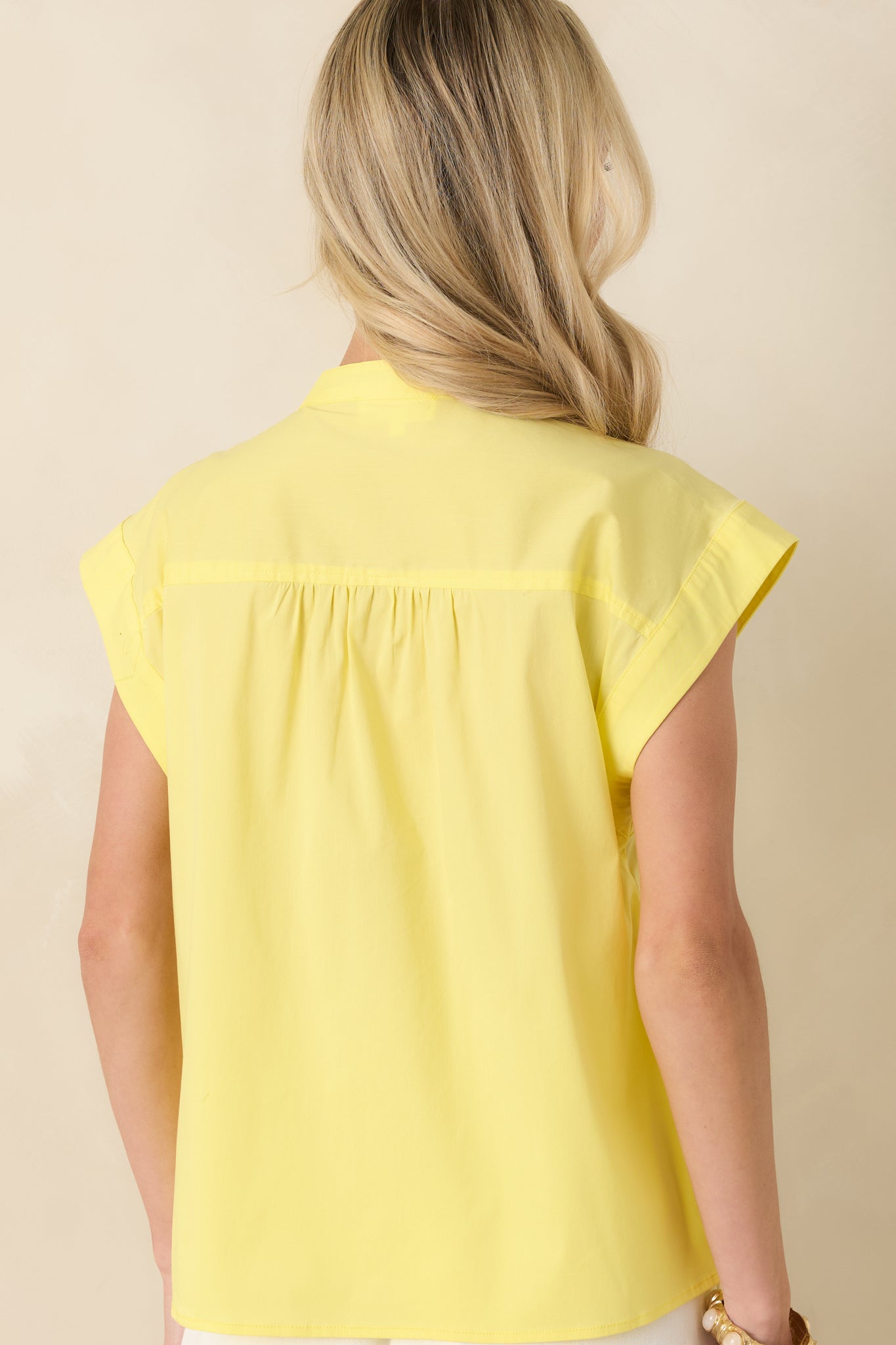 Yellow cotton blend top from the rear, showing a clean silhouette with gathered shoulder shaping and smooth, uninterrupted fabric finish.