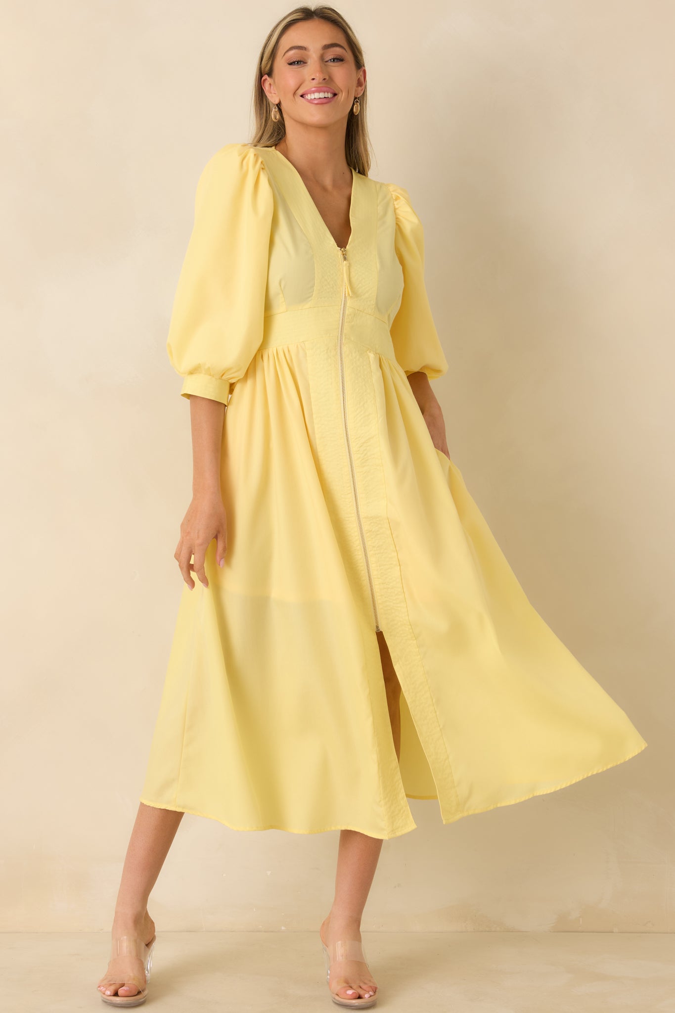 Yellow midi dress featuring a lightweight woven fabric, blouson sleeves, and a feminine silhouette that drapes with movement.