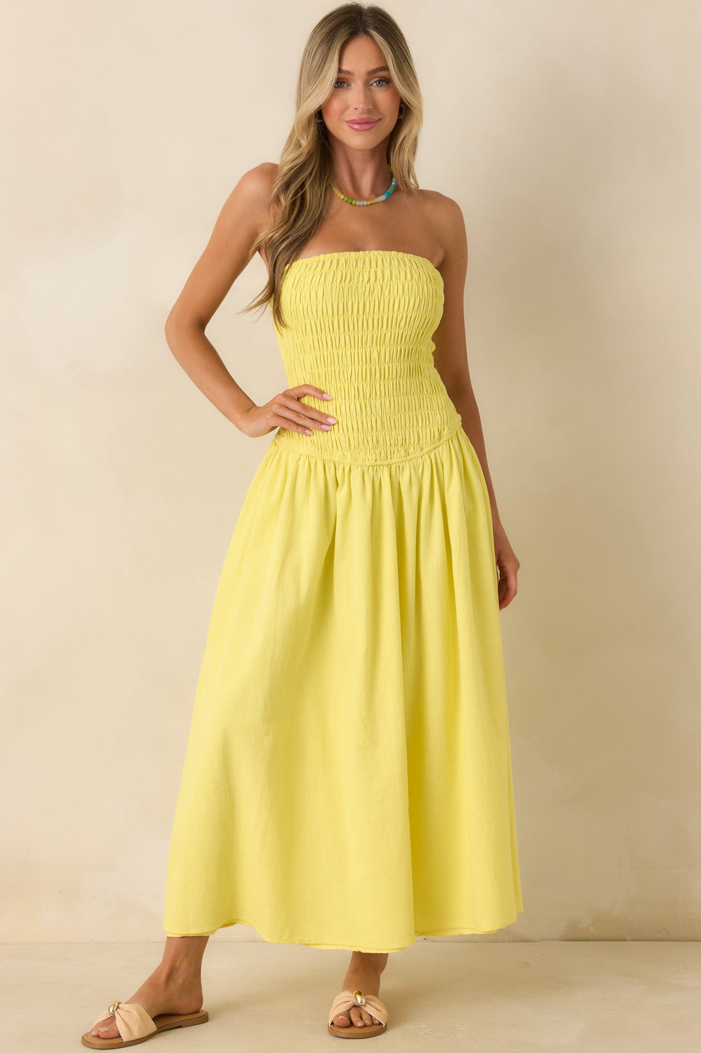 Yellow flowy maxi dress featuring a fully smocked upper bodice and relaxed, sweeping skirt design.