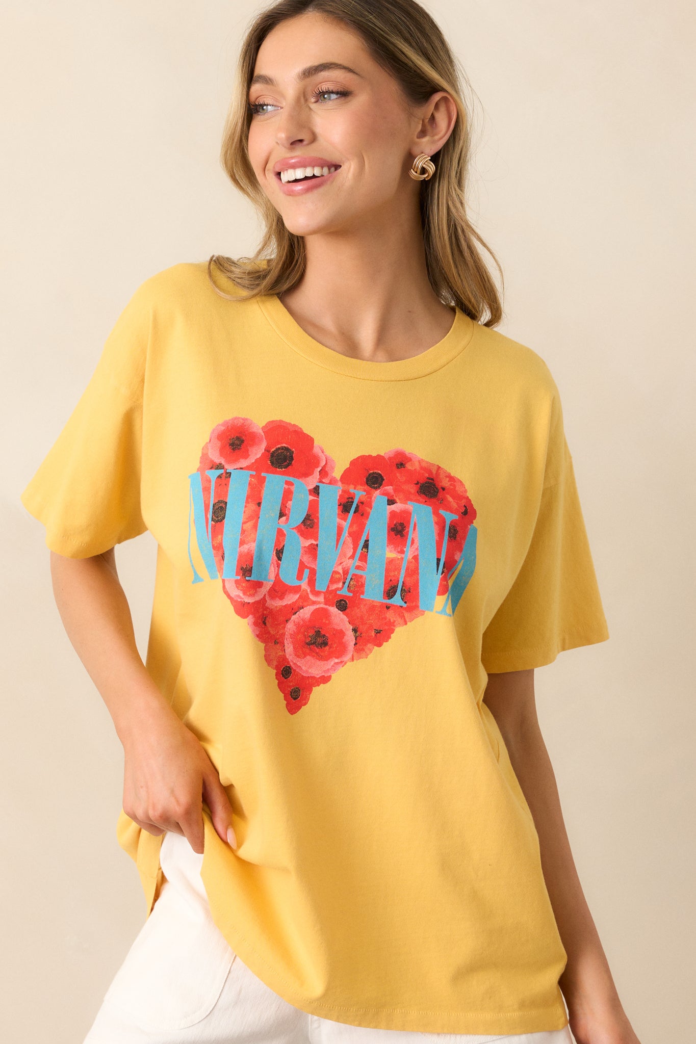 This yellow graphic tee features a crew neckline, short sleeves, and a relaxed fit, with a vibrant heart full of flowers on the front.