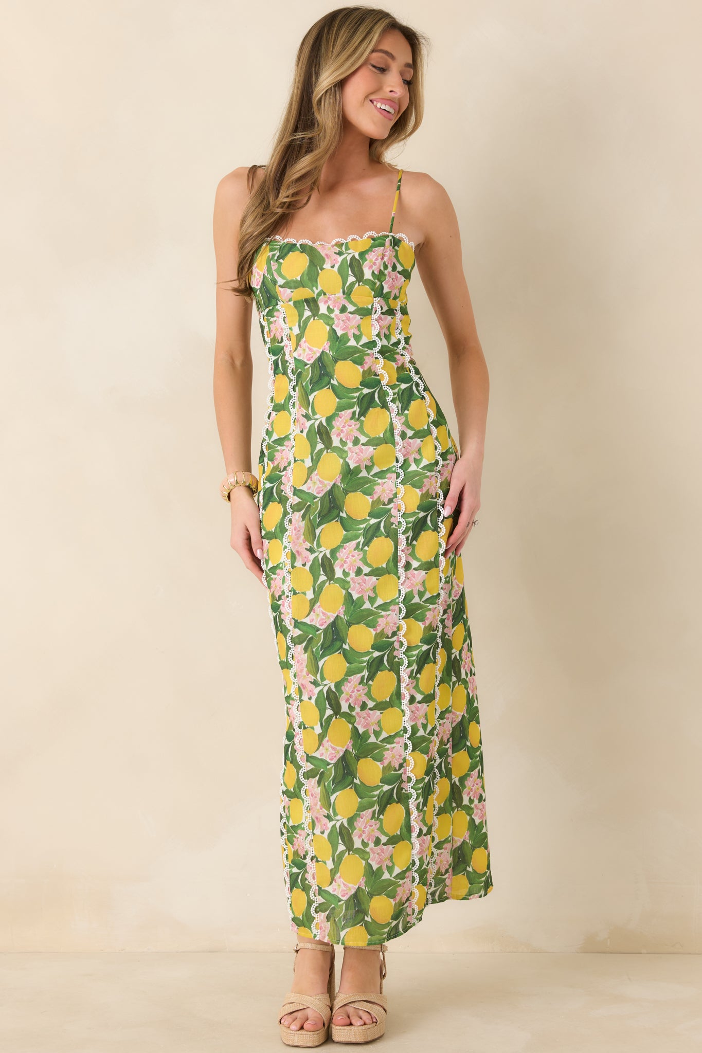 Yellow multi maxi dress with an allover lemon and floral print, contrast lace trim at the neckline, and a fitted bodice flowing into a straight maxi-length skirt.