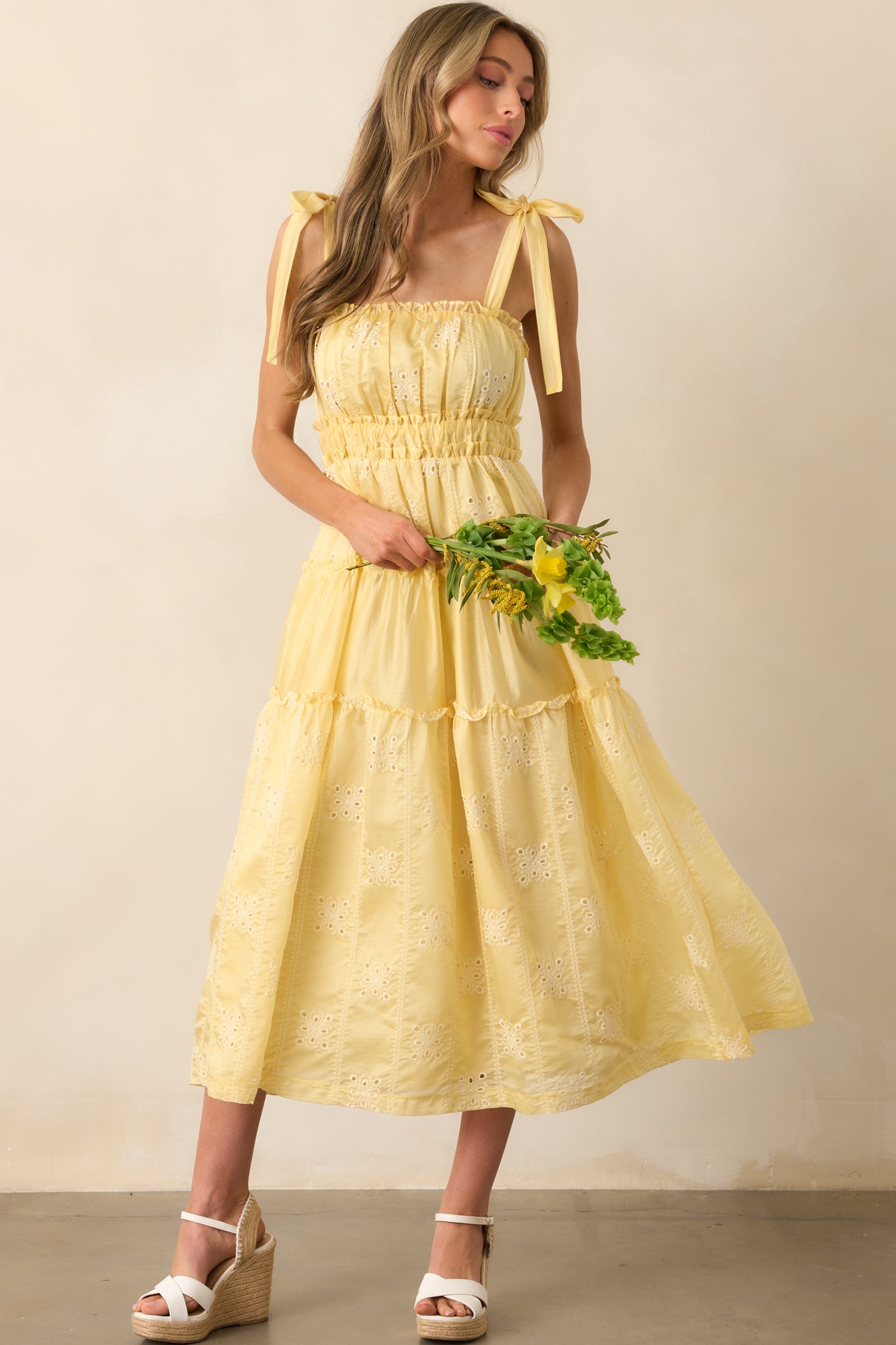 Flowing yellow midi dress featuring adjustable self-tie bow straps and a comfortable elastic waist.
