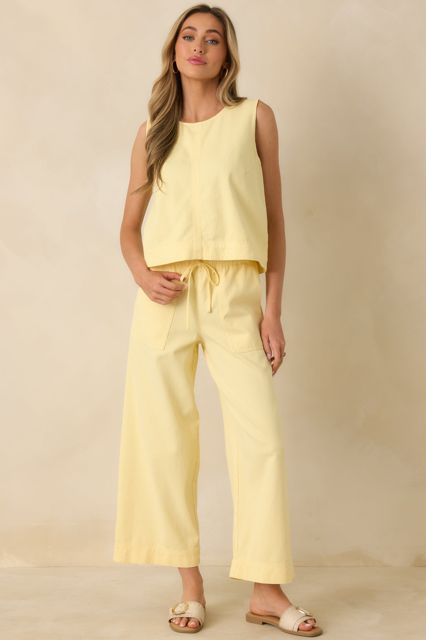 Yellow pants designed with a relaxed wide-leg shape, elastic waist, and casual functional side pockets.
