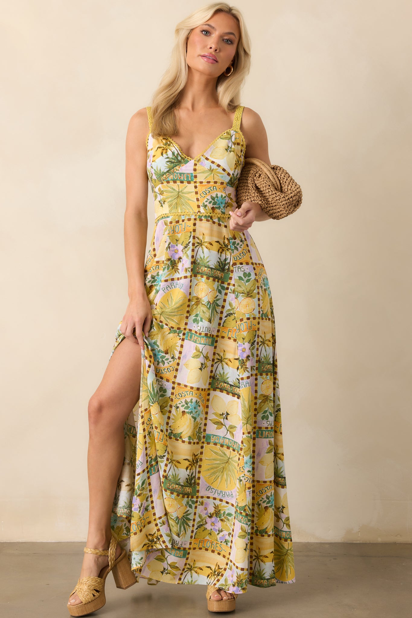 Yellow tropical print maxi dress with a v-neckline and flowing silhouette shown front-facing with adjustable straps.