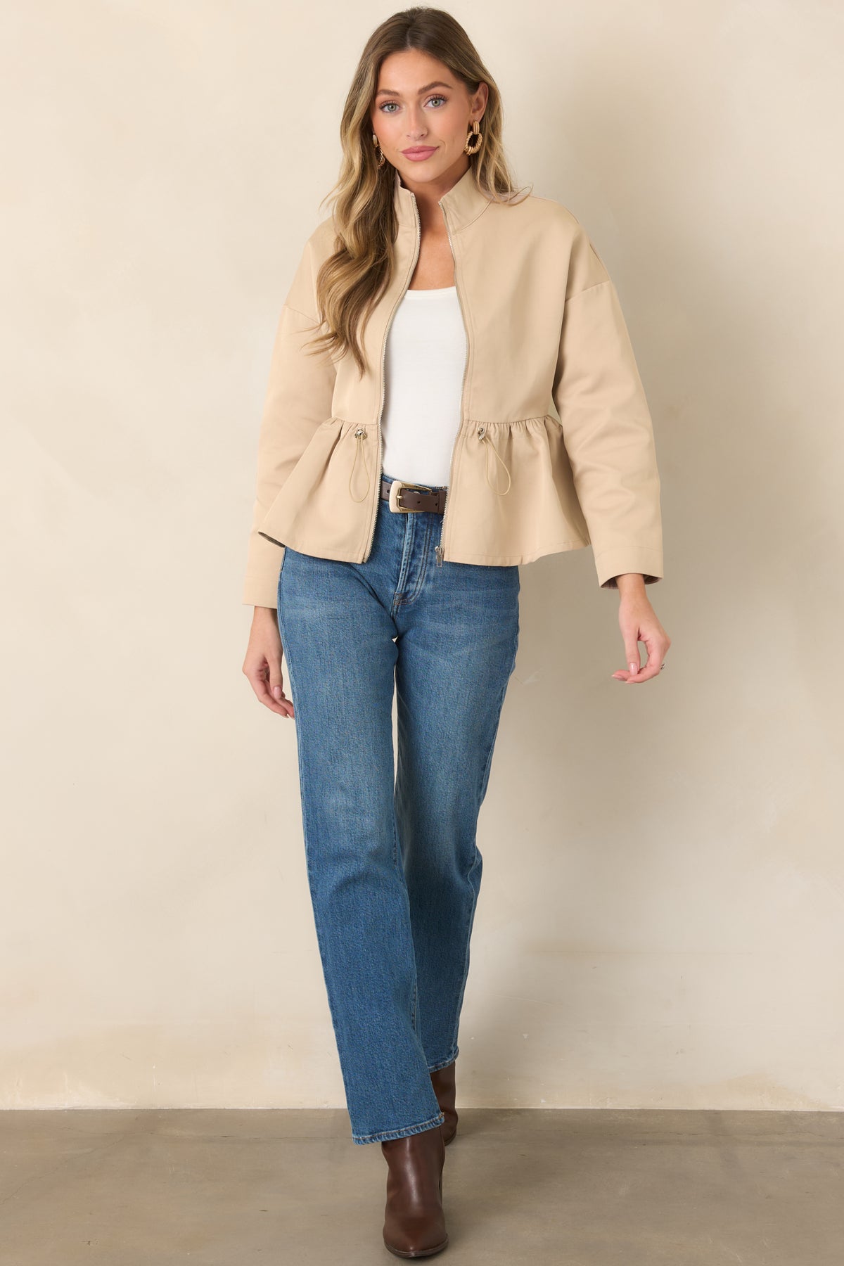 Zip-front jacket showcasing dropped shoulders and a softly gathered peplum hem.