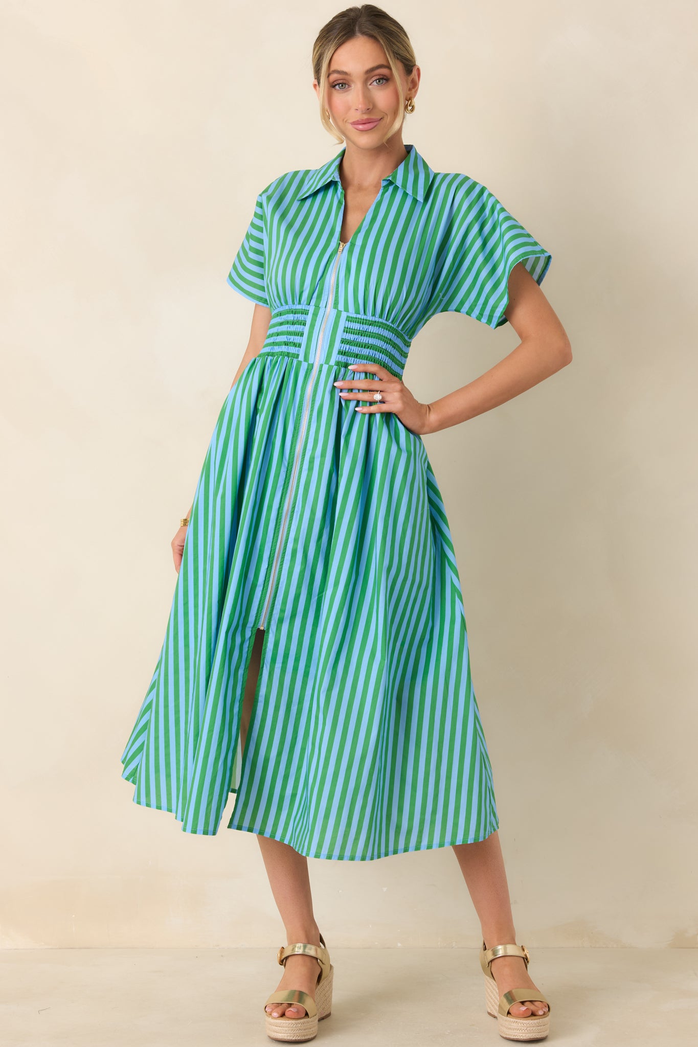 Zip-front light blue and green striped midi dress with a structured collar, relaxed short sleeves, and breezy skirt movement.