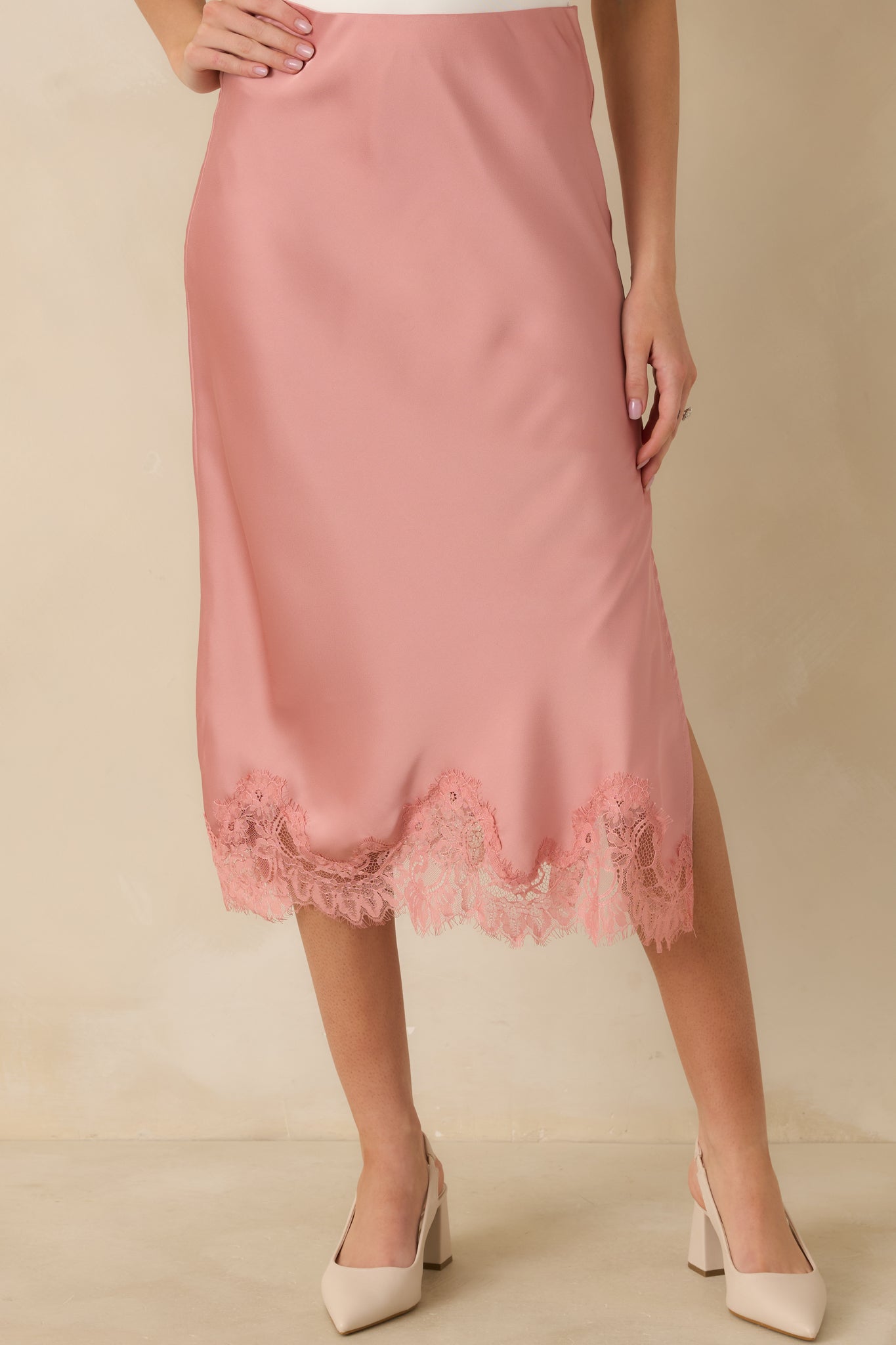 Zoomed-in image of the blush satin skirt highlighting the scalloped eyelash lace trim along the hem.