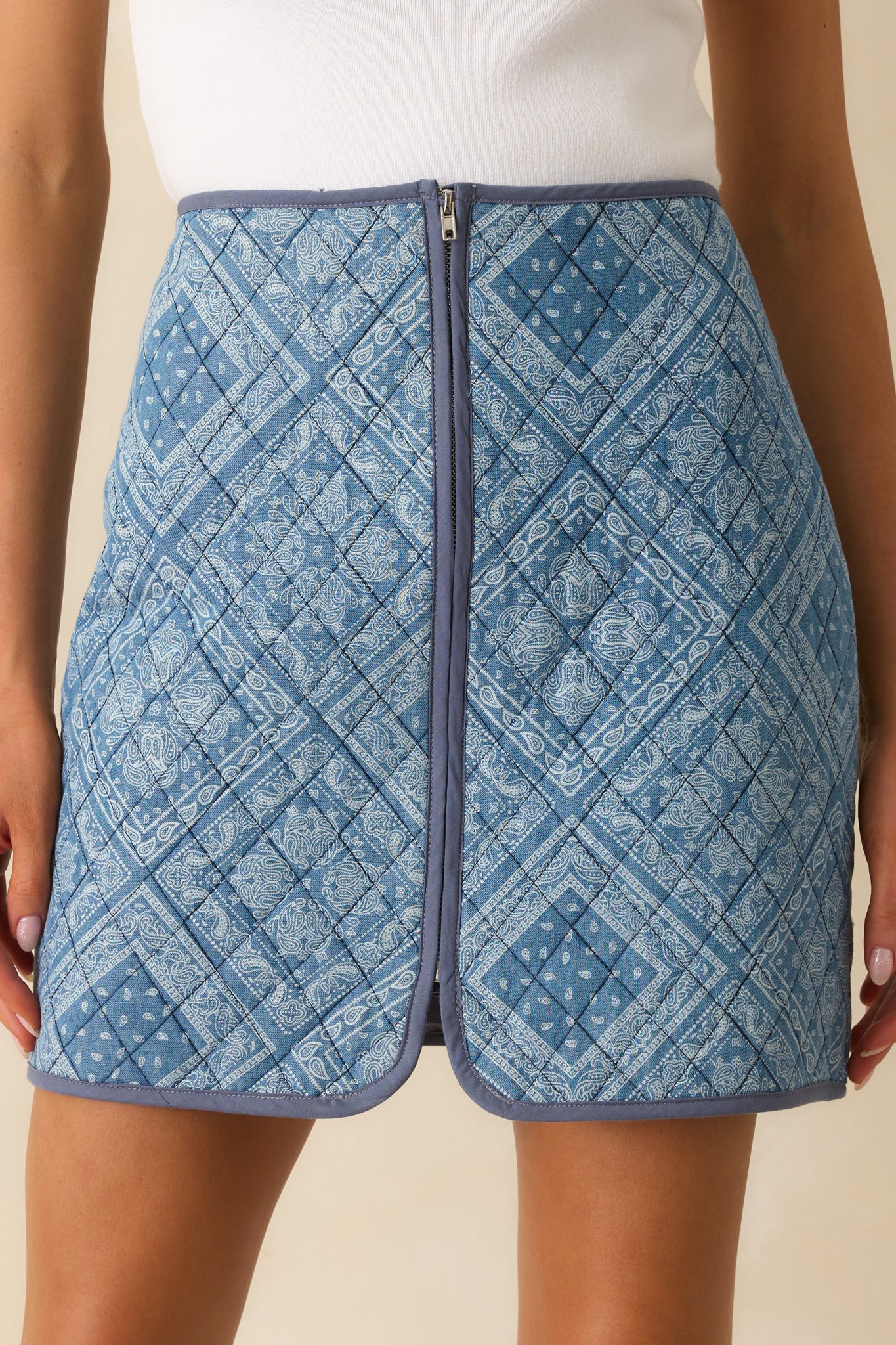 Zoomed-in shot of the quilted mini skirt, emphasizing the high waist and geometric paisley print.