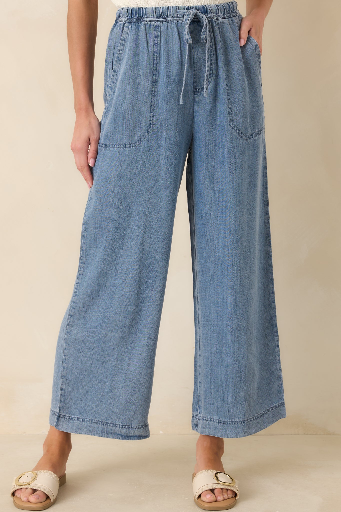 Zoomed view of drawstring waist and soft, flowing fabric in wide-leg pants.