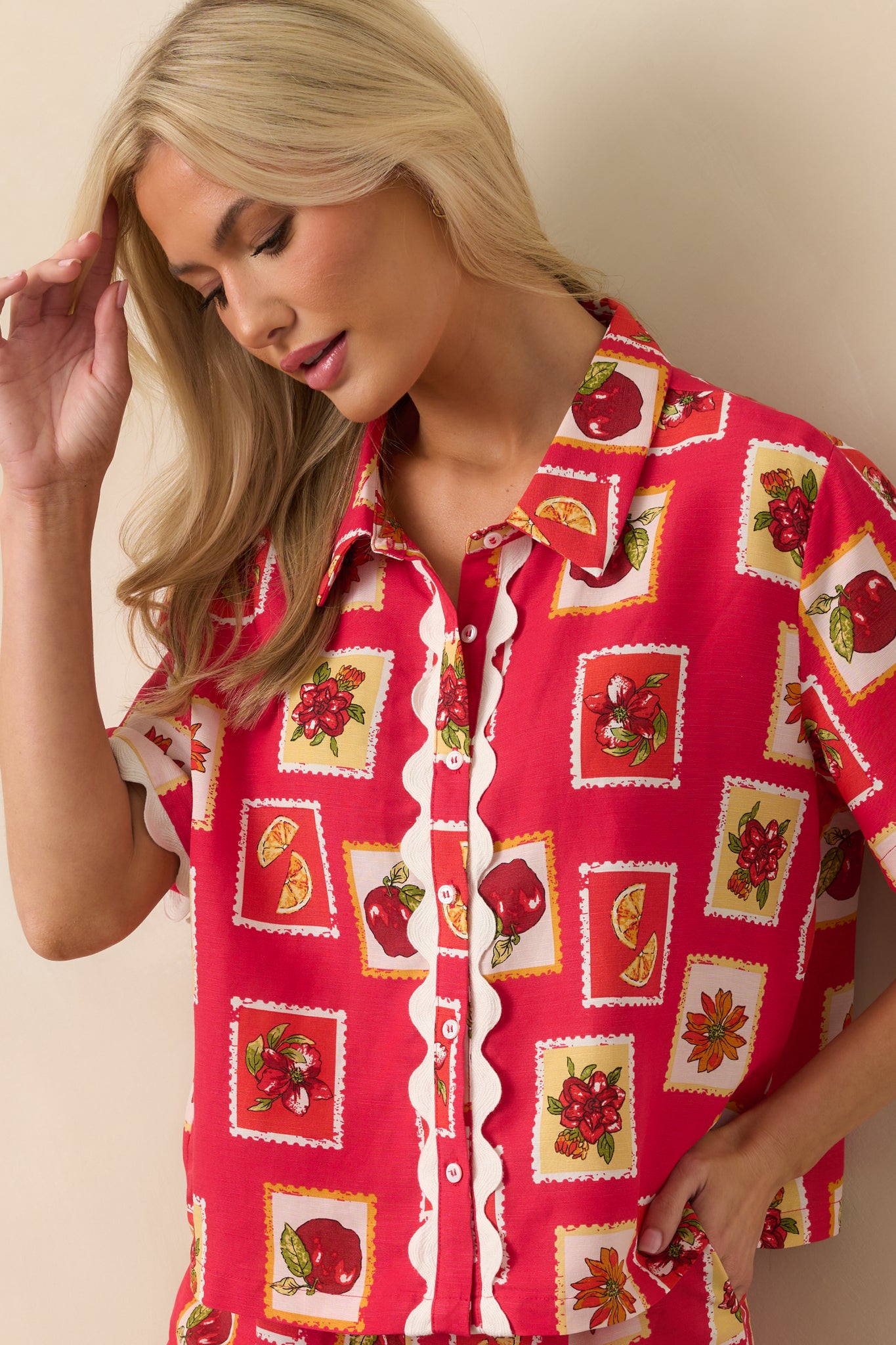 Zoomed-in view of the button front detail on the red patchwork print top, showing contrast between the print and trim.