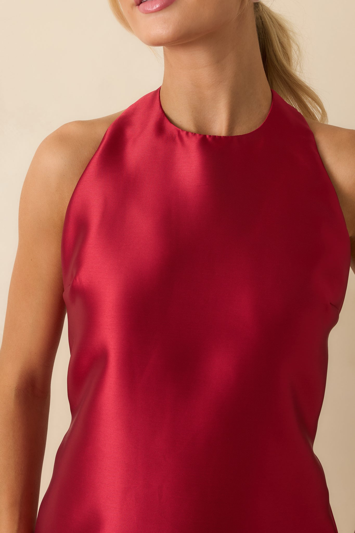 Zoomed-in view of red satin fabric with smooth lining and subtle shine.