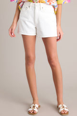 Front view of thse white denim shorts with high waist, button and zipper closure, belt loops, and front & back pockets.