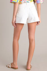 Back view of these white denim shorts with high waist, button and zipper closure, belt loops, and front & back pockets.