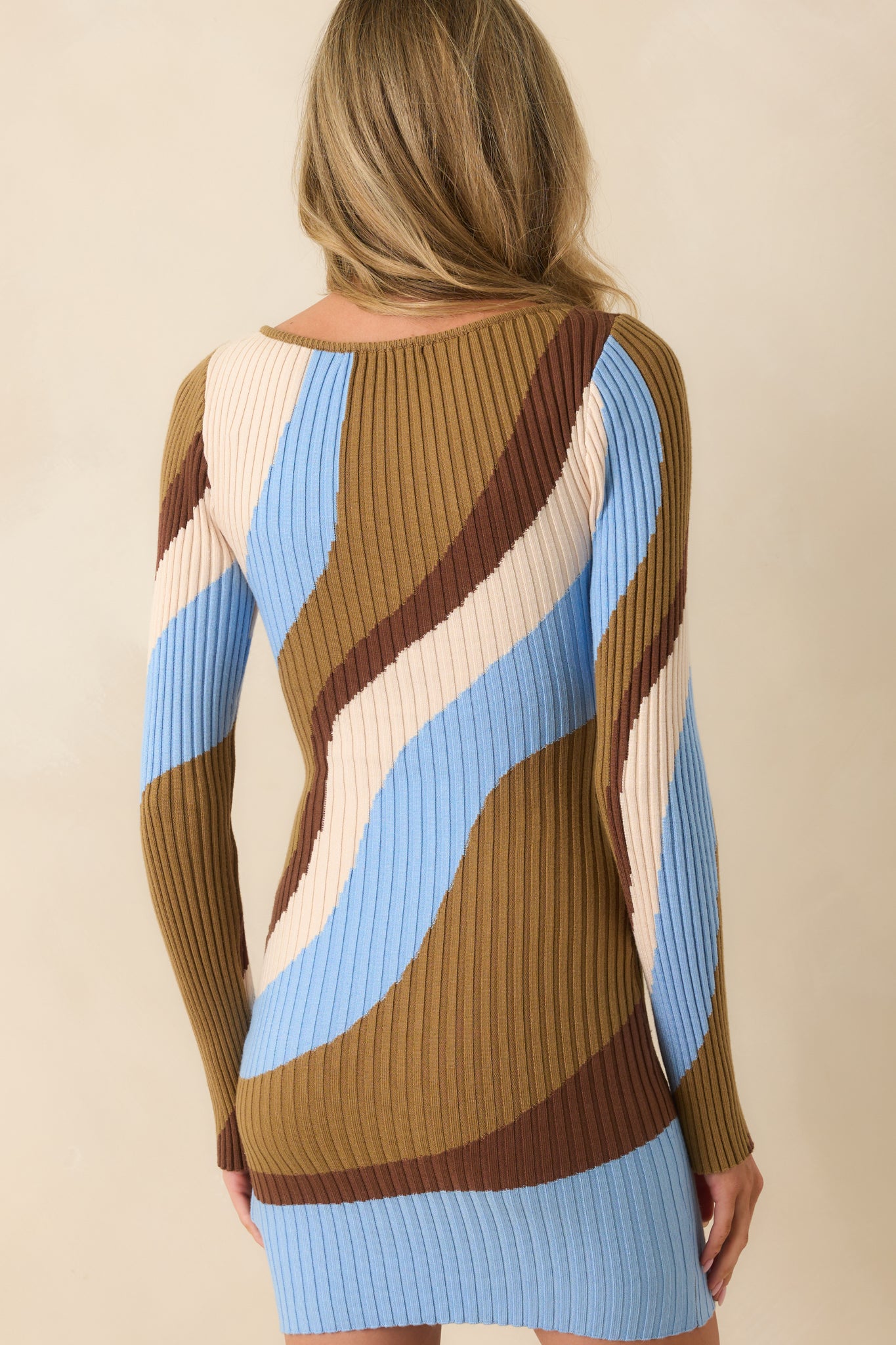 Rear view of blue and neutral abstract print mini dress with long sleeves and fitted silhouette.