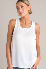 Front view of this white tank top that showcases a classic scoop neckline, stylish slits up the sides of the bottom hem, and a lightweight fabric for effortless comfort and style.