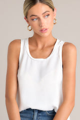 Close up front view of this white tank top that showcases a classic scoop neckline, stylish slits up the sides of the bottom hem, and a lightweight fabric for effortless comfort and style.