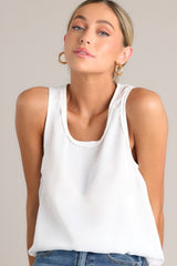 This white tank top showcases a classic scoop neckline, stylish slits up the sides of the bottom hem, and a lightweight fabric for effortless comfort and style.