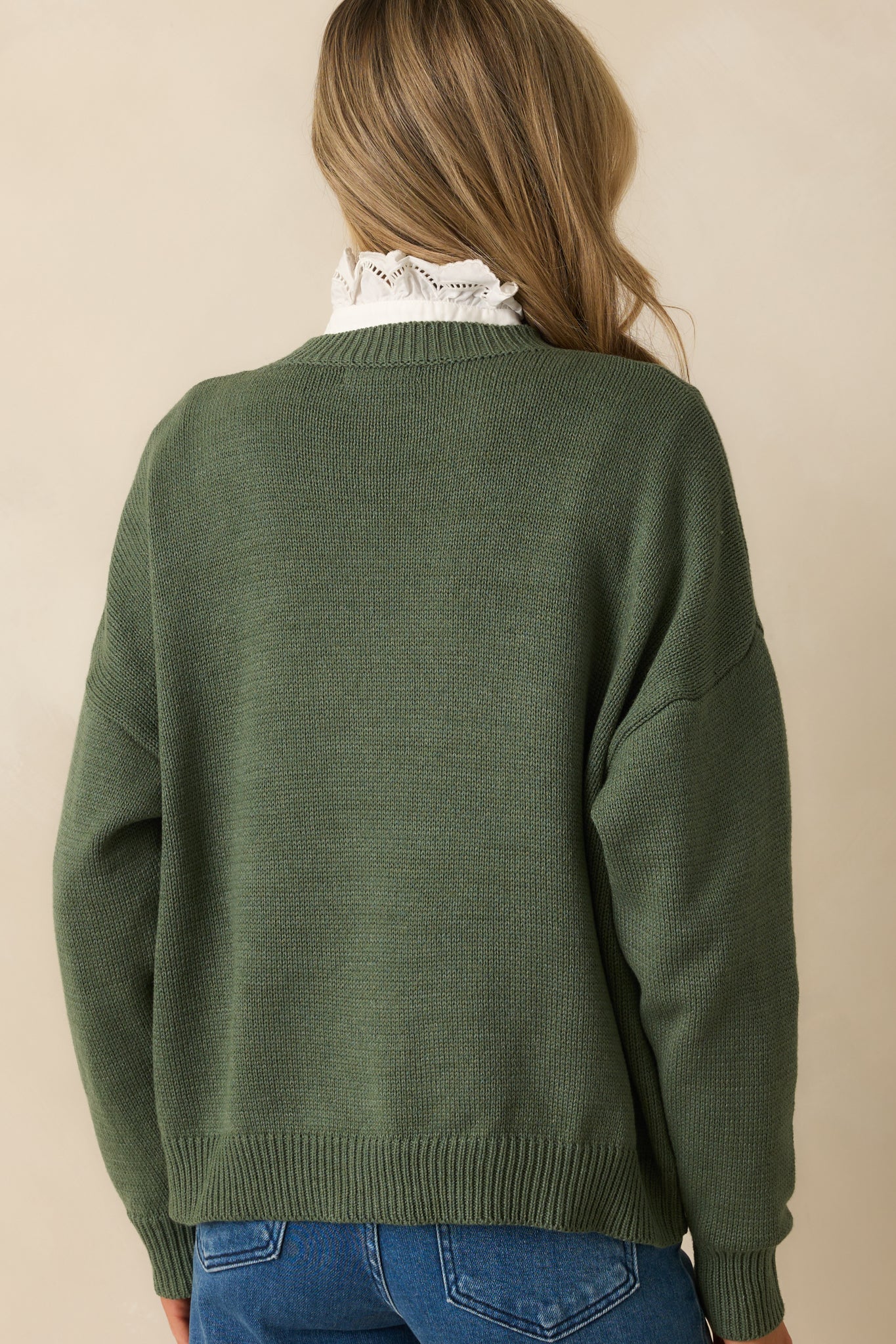 Back view of green cotton-blend sweater with relaxed fit and ribbed finishing details.