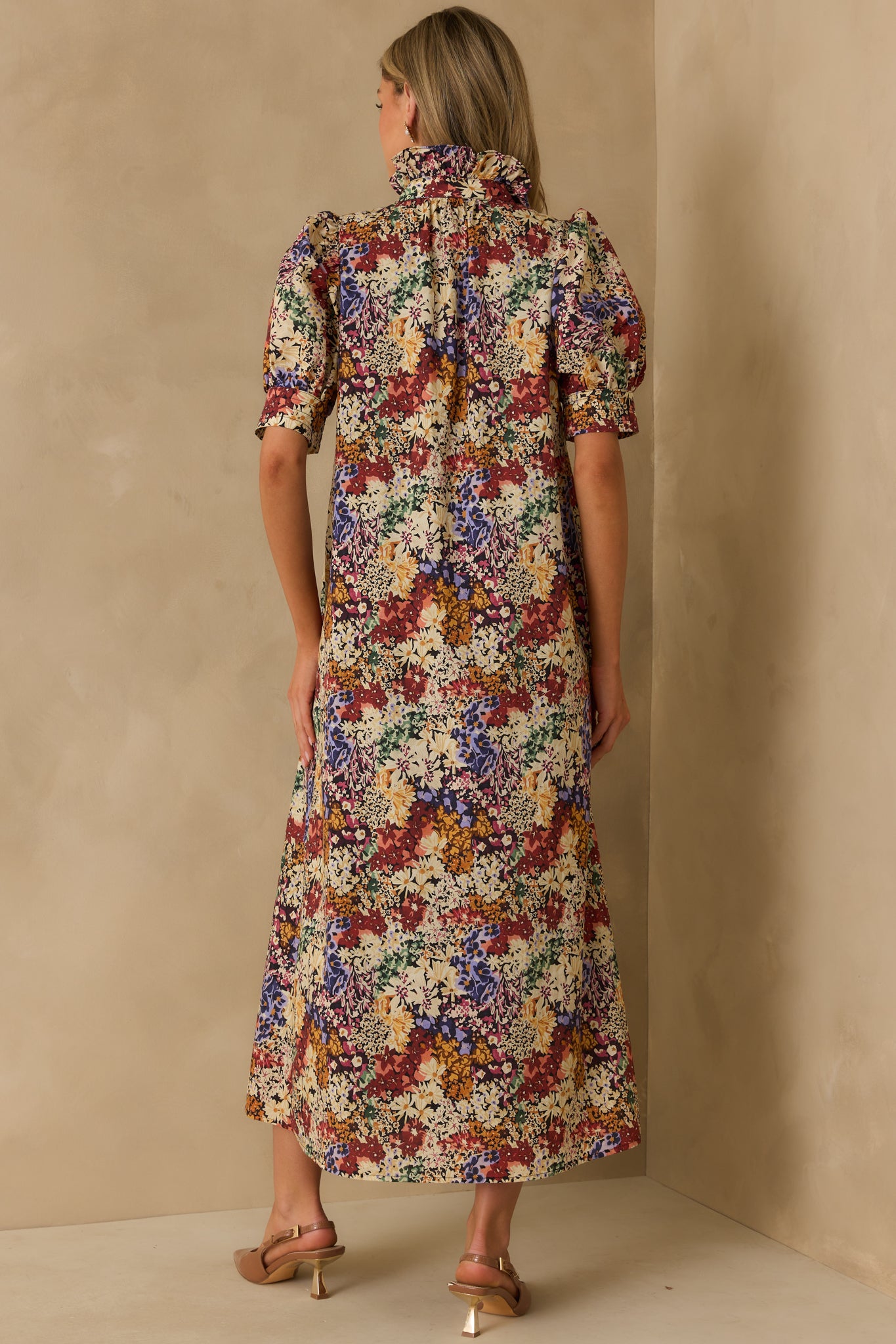 Rear view of the ivory floral maxi dress with a multicolor print, puff sleeves, and flowing relaxed fit.