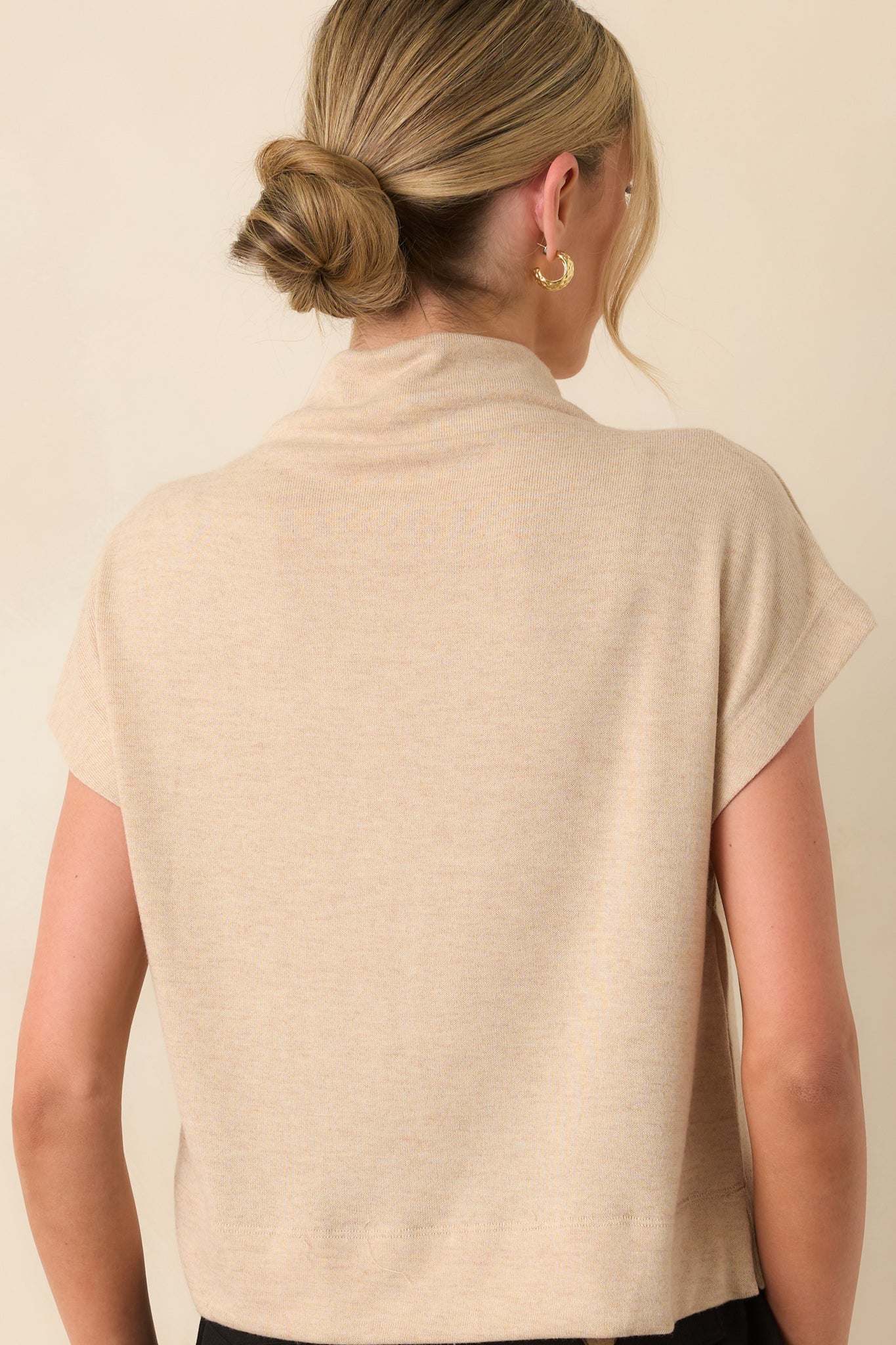 Rear view of the top displaying the smooth back panel and relaxed fit continuing through the back hem.