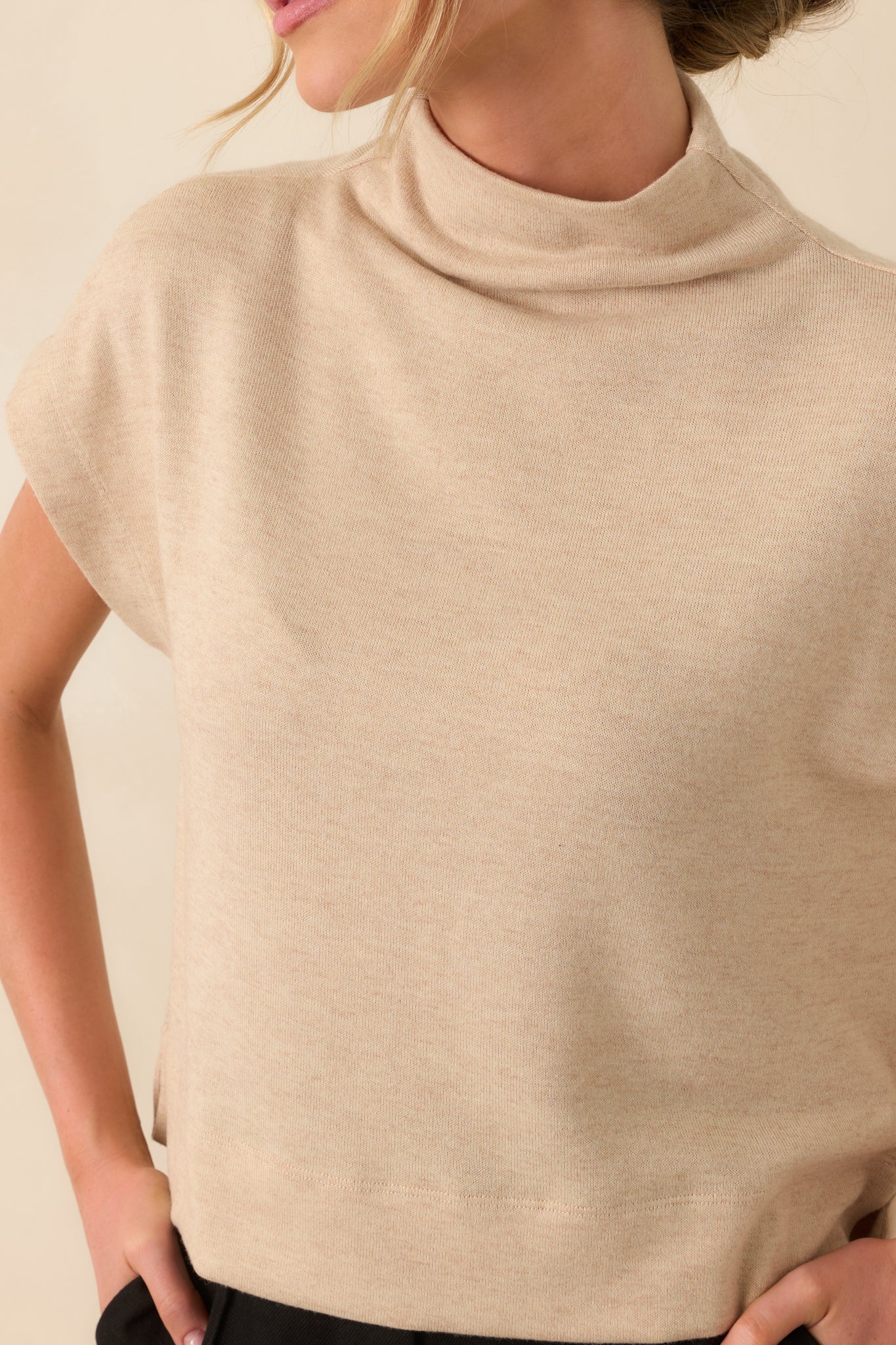 Close-up of the neckline and upper chest area showing the soft roll of the mock neck and fabric texture.