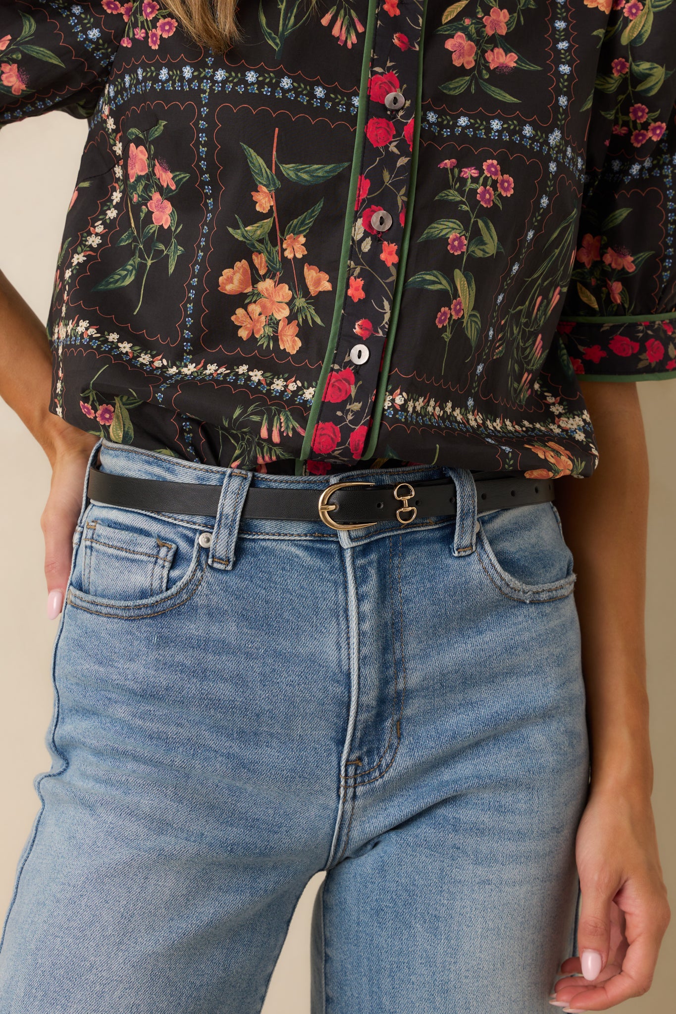 Angled cropped shot highlighting the clean structure of the black faux leather and the matching belt keepers.